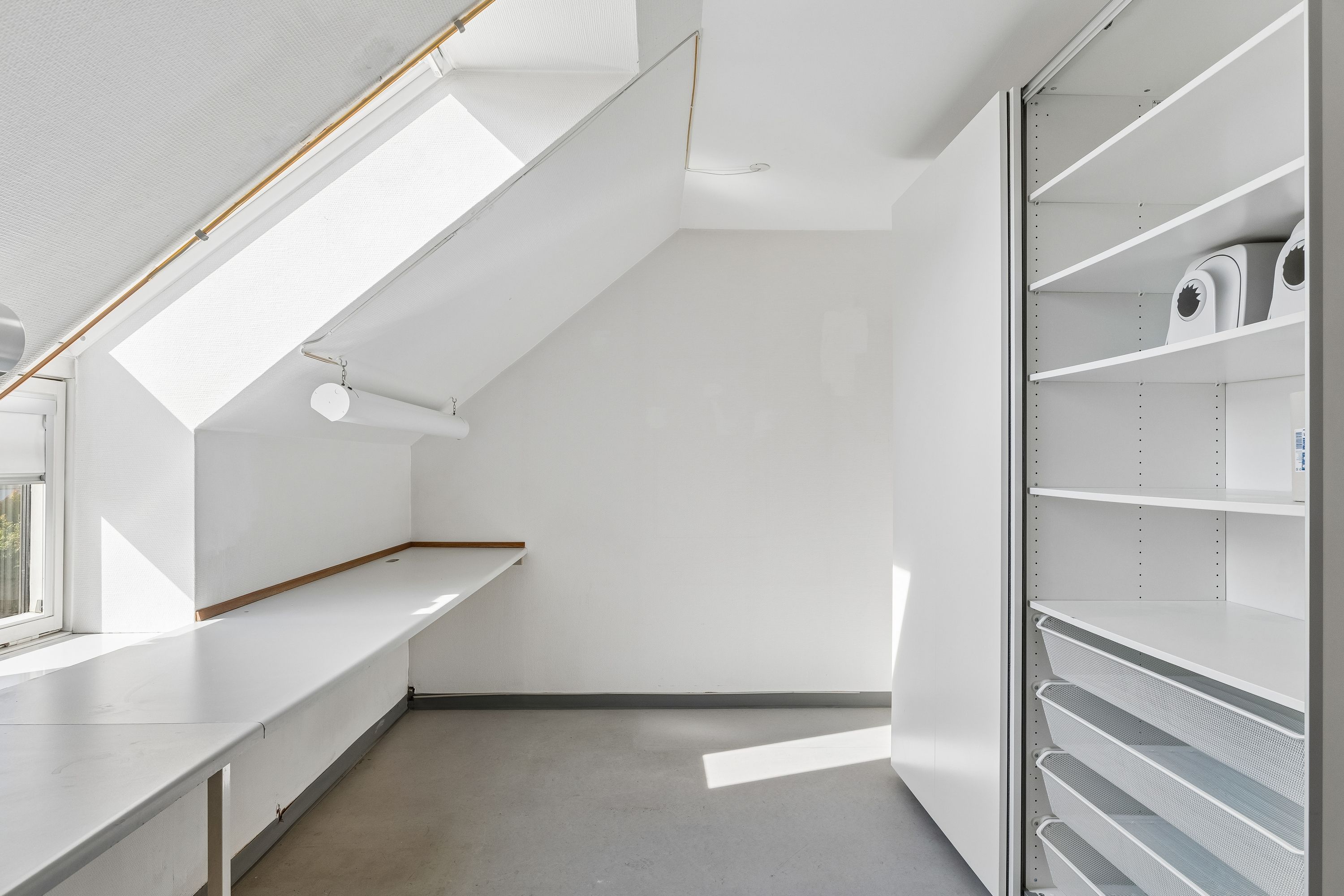 Et lyst og veludstyret kontor med lyse lofter, store vinduer og moderne møbler