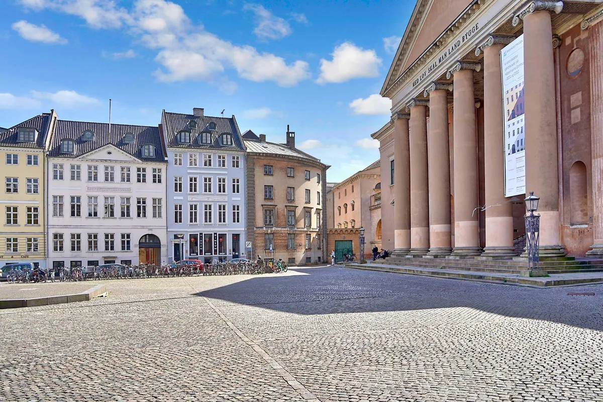 Kontorlejemål i København med udsigt over Nytorv, Gammel Torv og Københavns Byret. Flere cykler parkeret og folk går på gågaden foran bygningen