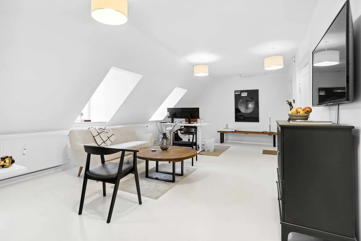 Kontor med skrivebord, computere, sofa, bord og stålampe samt udsigt fra vindue over Nytorv, Gammel Torv og Københavns Byret
