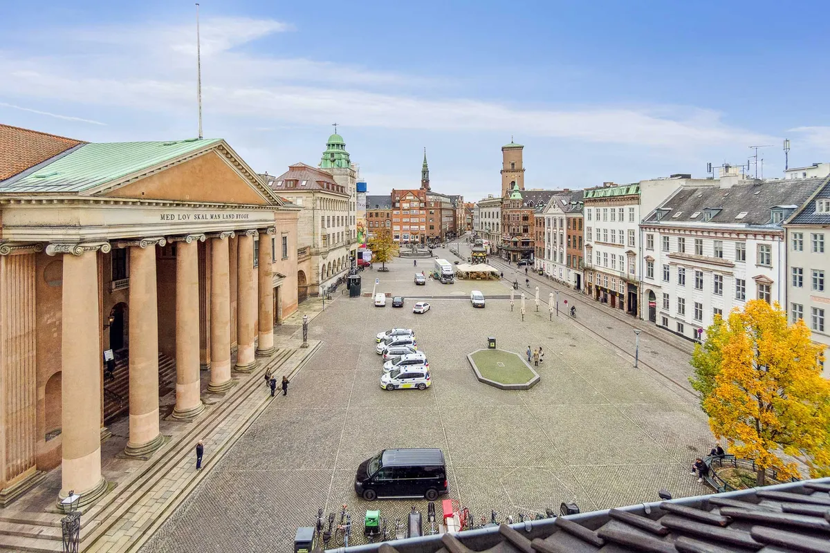 Kontorlejemål med udsigt over Nytorv, Gammel Torv og Københavns Byret i København. Mange biler parkeret og gående folk i baggrunden