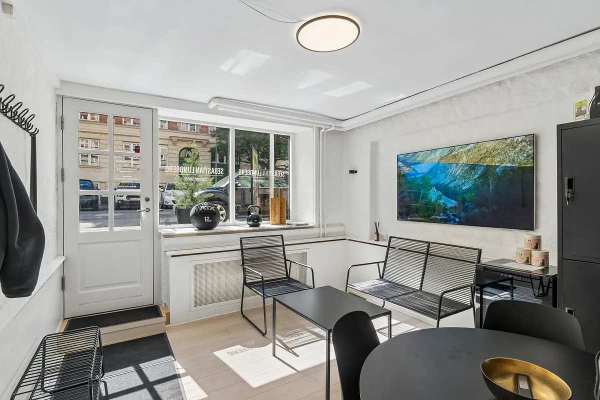Kontor til leje i Frederiksberg med moderne indretning, åbent vinduesparti, tv på væggen, moderne møbler og lyse loftslamper