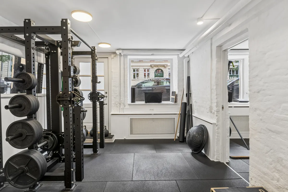 Gym med barbell, kettlebell, trækapparater, stang og vinduer med byudsigt til Roarsvej 6, Frederiksberg