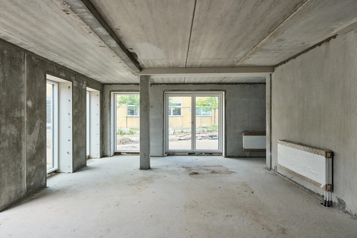 Moderne erhvervslejemål med glasdøre, vinduer, to radiatorer og høje betonvægge