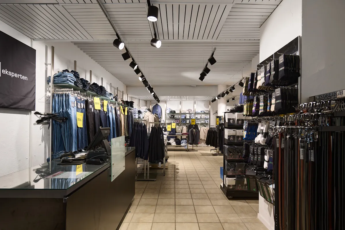 Lys, velplejet butikslejemål med tøj i udsalg, salgsdisk og køkken. Lejligheden har køkken og 127 m² til leje