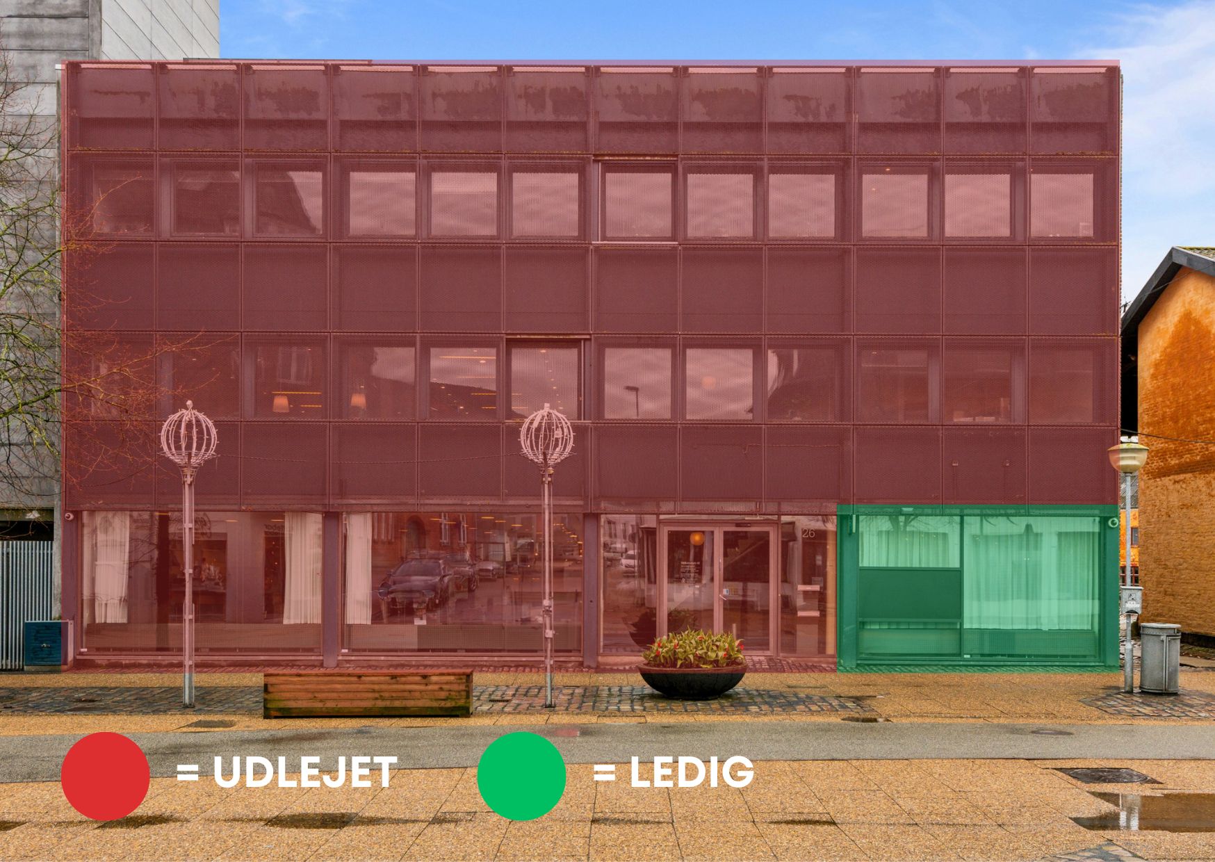 Lejemålet på Østergade 26A i Hjørring er synligt med rød facade og grønne ruder samt en søjle med rødt lys