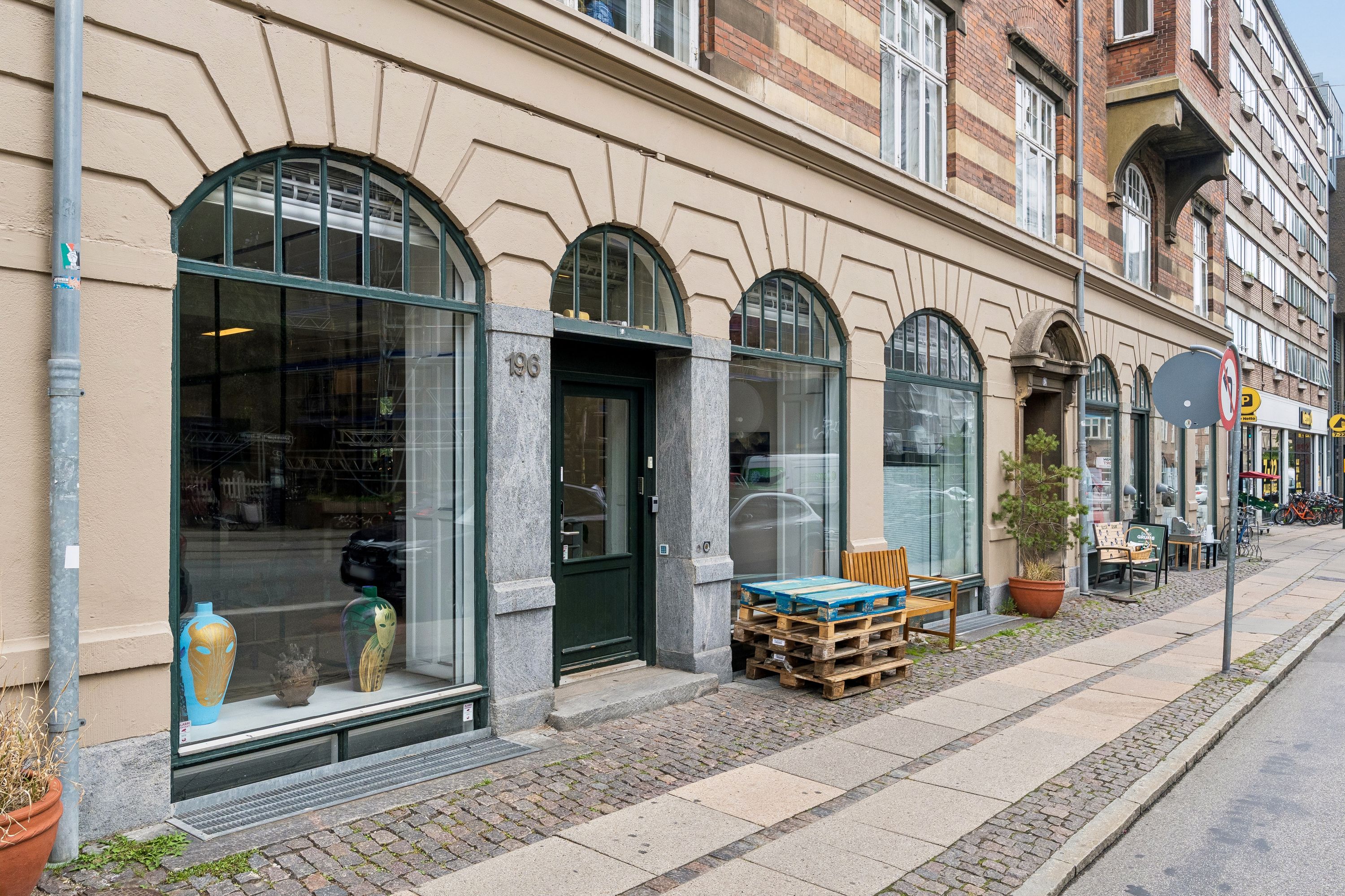 Butik med store glasvinduer og flotte møbler udenfor på Vesterbrogade 196. Butikken har flotte vasekunstværker i vinduet og er nummer 196.