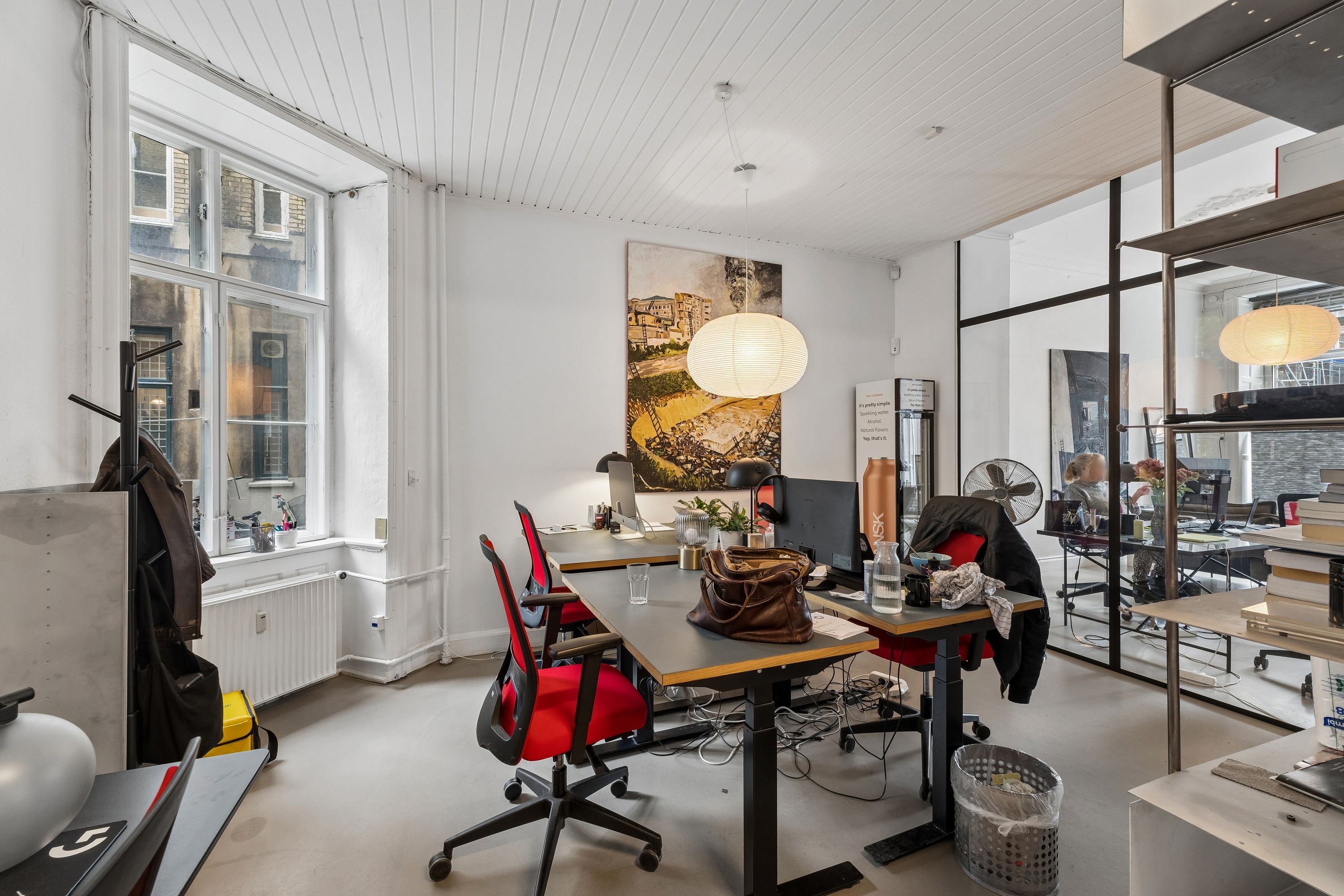 Kontor med høj synlighed på Vesterbrogade 196, st. th. Erhvervslejemål med store vinduer og lyse lofter. Kontorbord med computer og lyse stolpelampe i det åbne rum