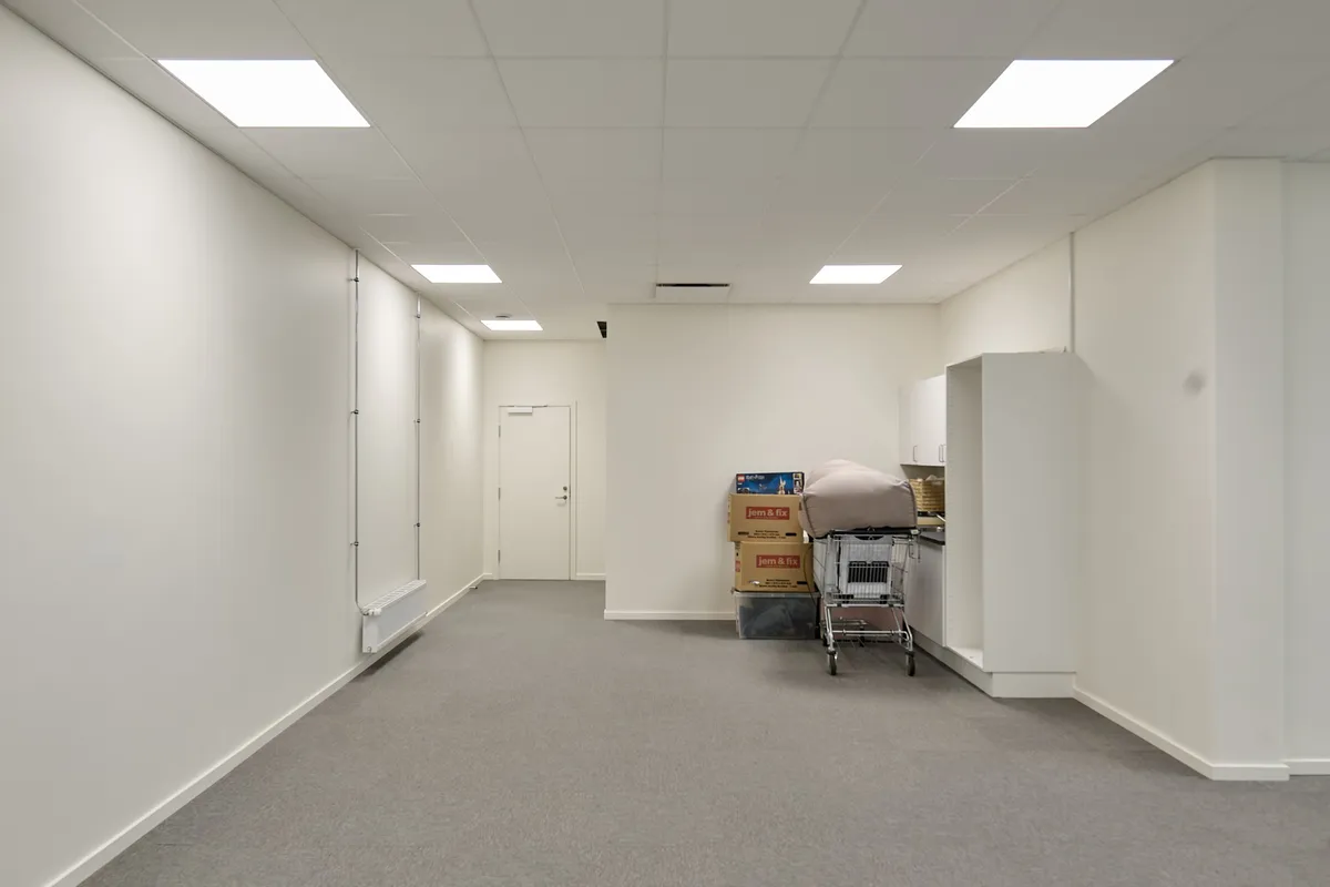 Lyserummet med to hvide vægge, et gulvtæppe og fire højre bokse er forbundet med to hvide høje og en høj stol. Fire hvide loftslampe er installeret på loftet