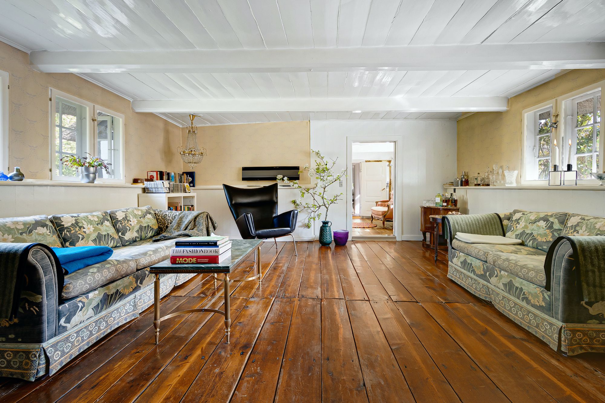 Et flot lyse stue med trægulv og møbler, der udstråler hygge og komfort i et hyggeligt hjem