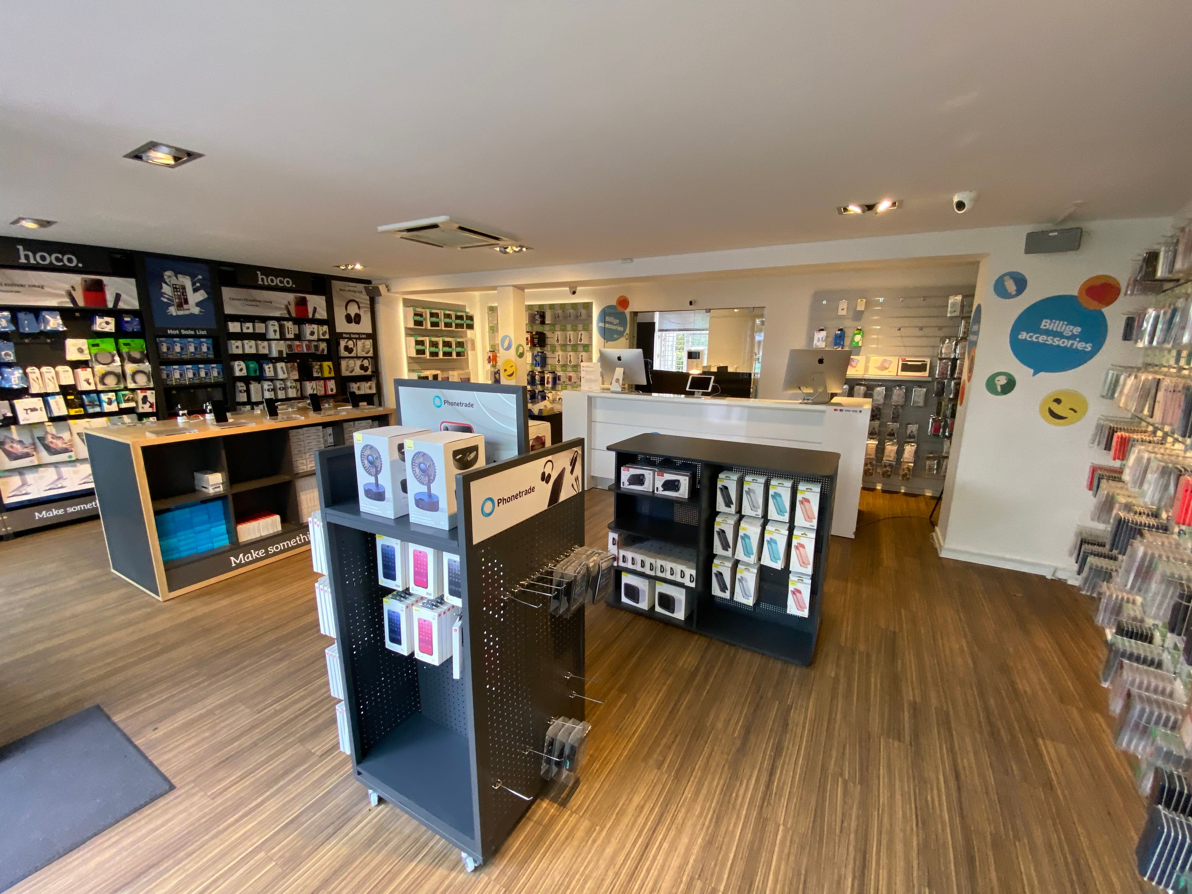 En mobiltelefonbutik med kunder og medarbejdere, som tilbyder tilbehør og elektronikprodukter.