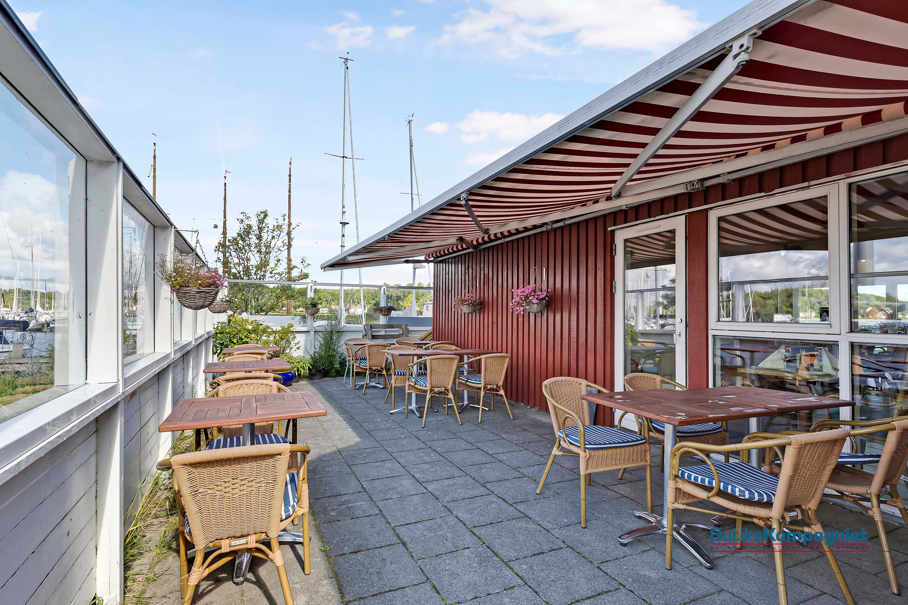 Havnudsigt over restaurant med terrasse, hvor der er smukke blomster og lyseborde