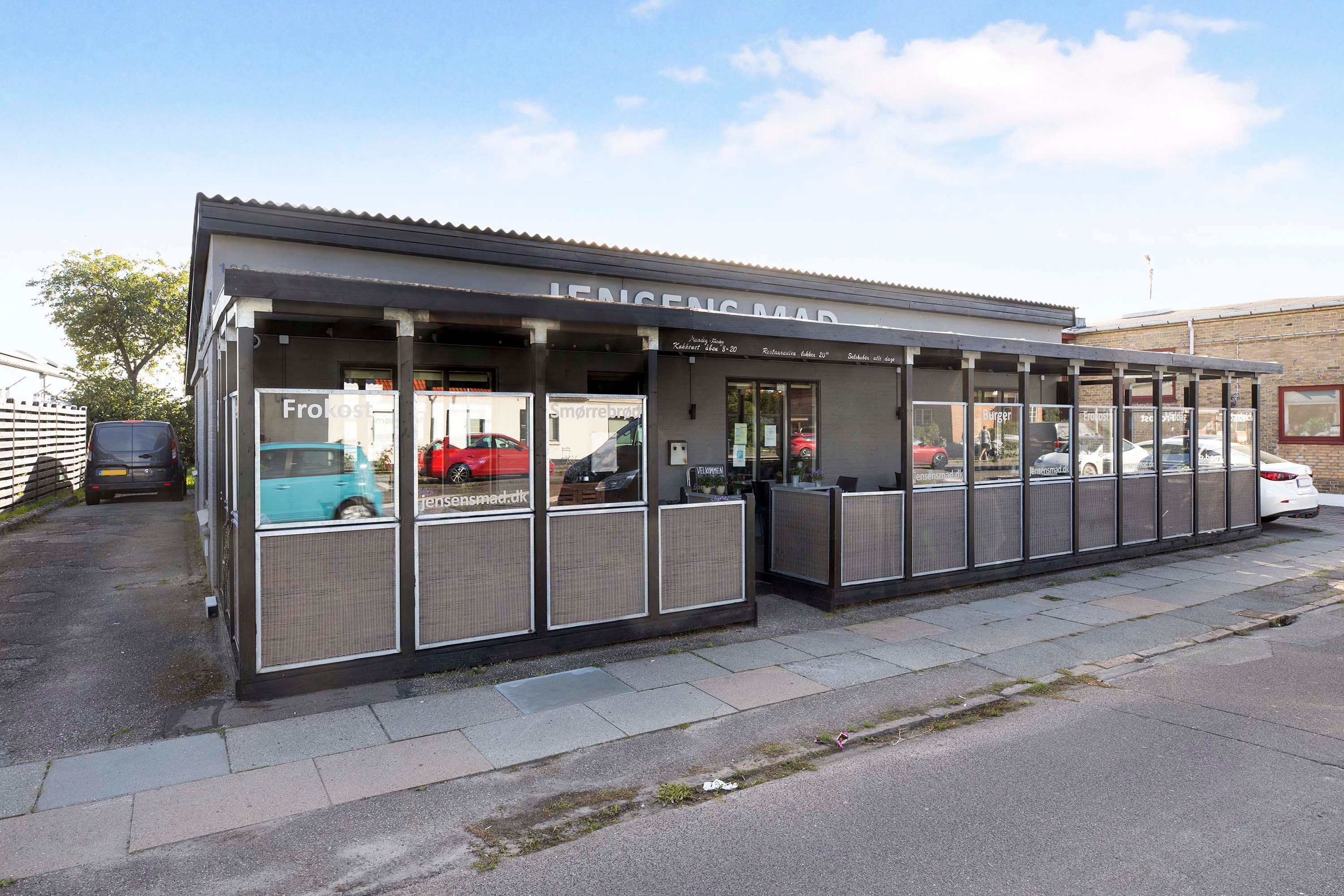Moderne restaurant med store vinduer og en terrasse med plads til 30 personer og parkeringsplads for fire biler