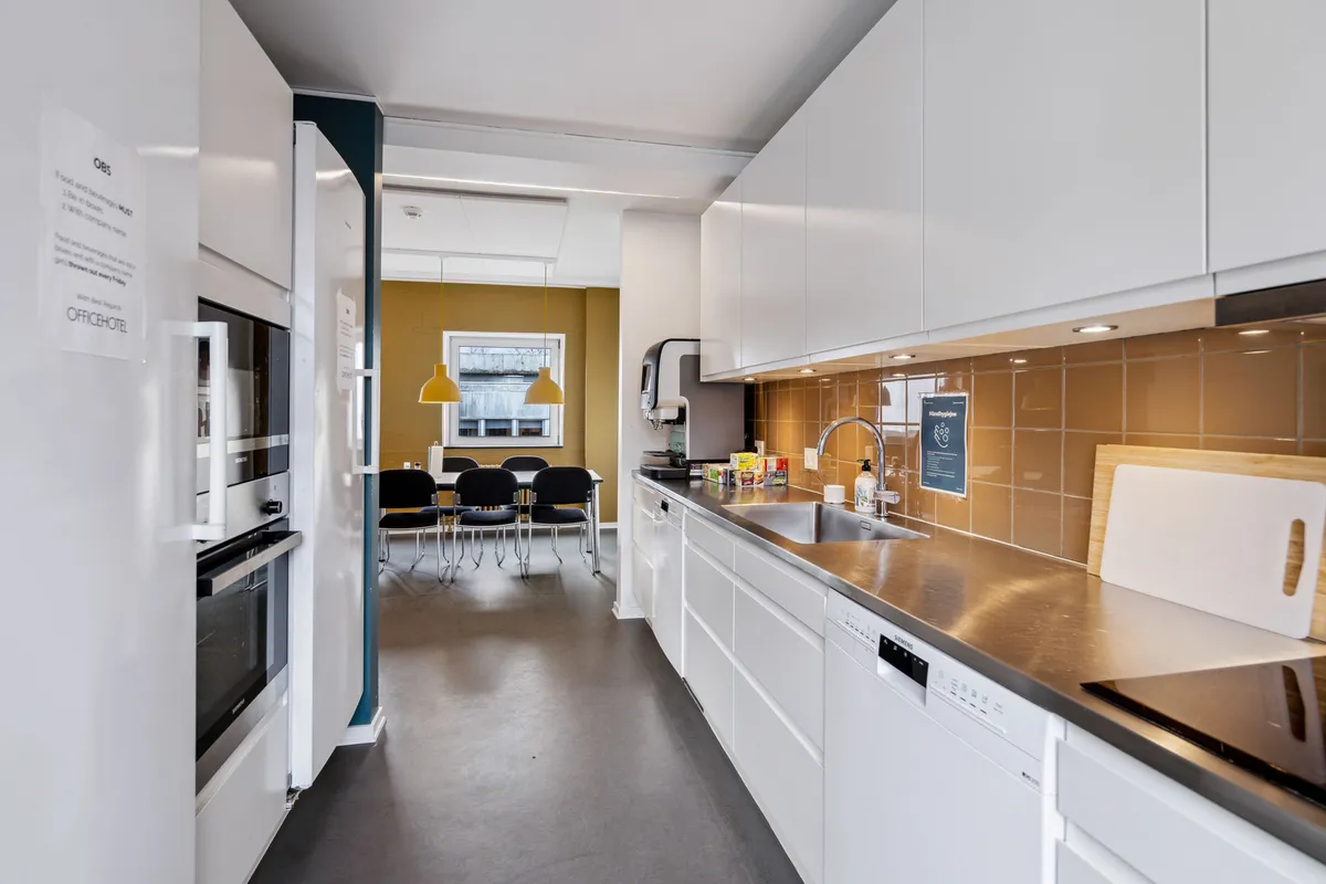 Rent privat kontor med køkken og spisebord, hvor der er en ovn og en vaskemaskine