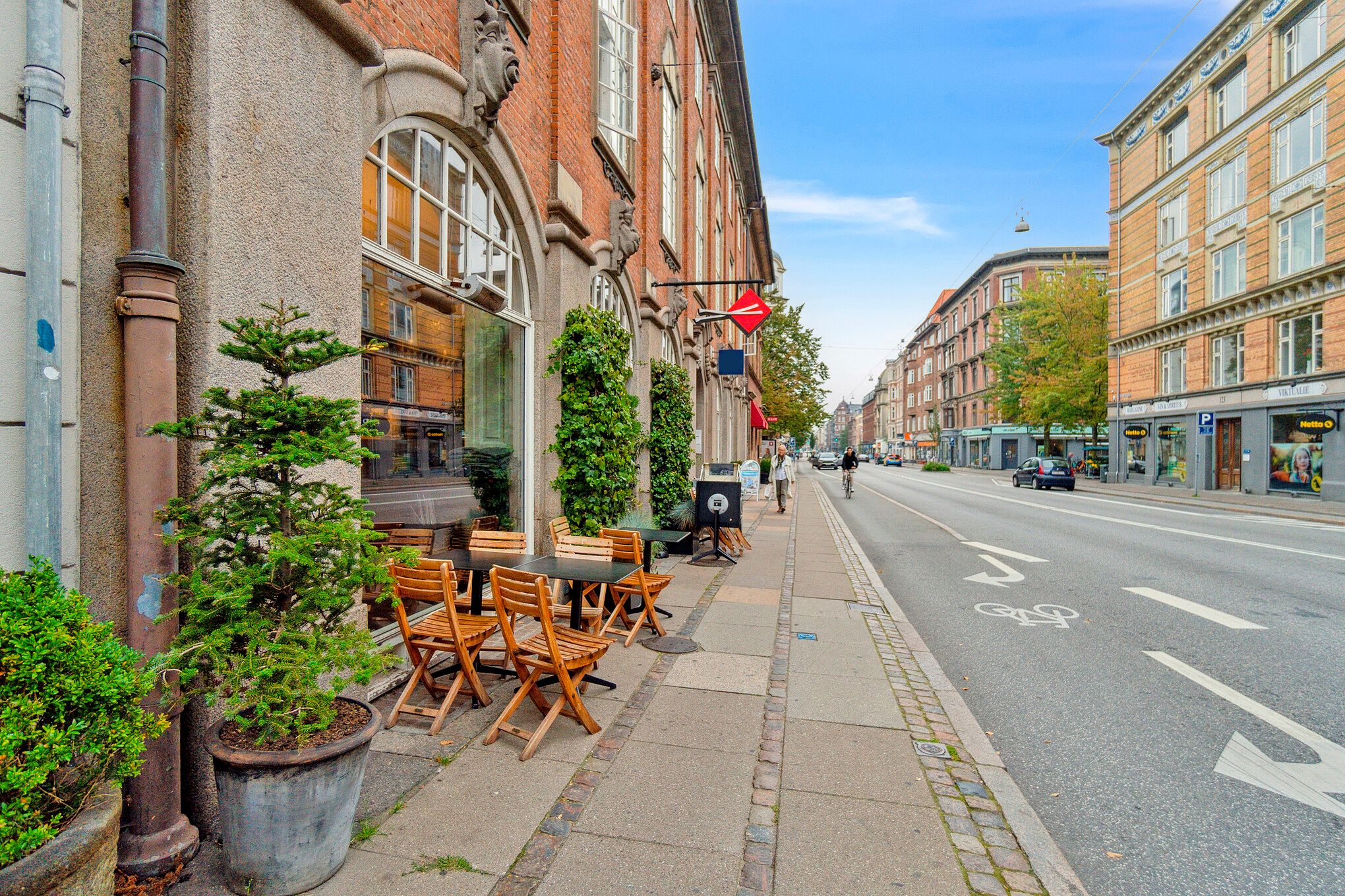 Frederiksberg-ejendom med smuk terrasse på gågaden og bygning med store vinduer og søjler