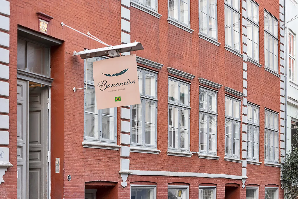 Rød murstensbygning med et hængende banner for Bananaeia restaurant med brasiliansk køkken