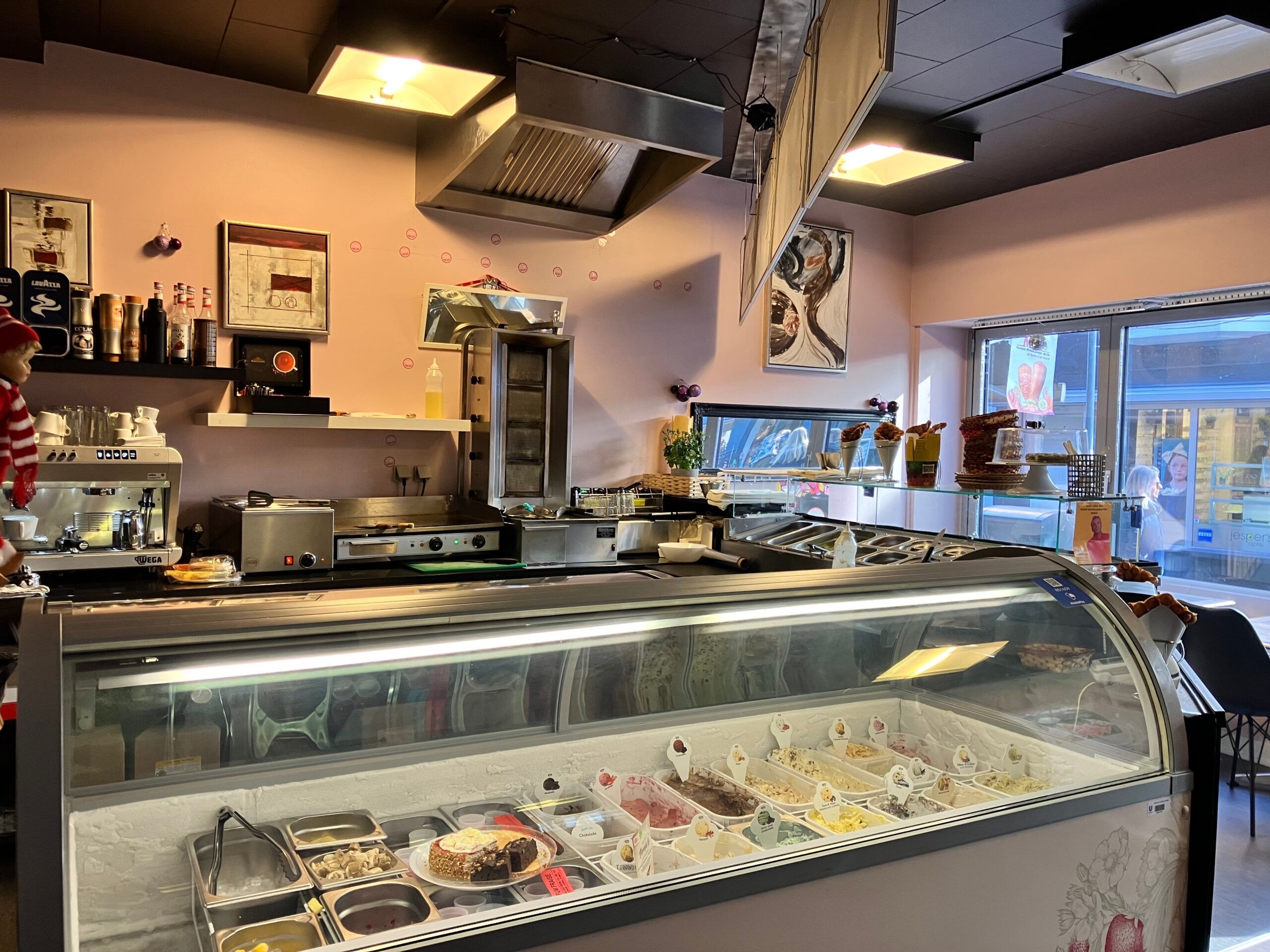 Isbar med flere forskellige is- og chokoladesorter og kebab bagved, og flere ting i baggrunden