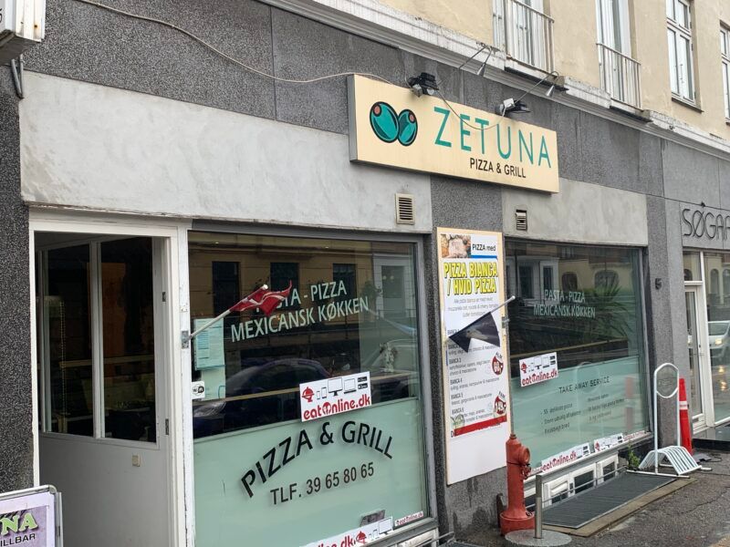 Zetuna Pizza og Grill i Hellerup. Tegn på pizza, kontaktnummer og “Take Away Service” er på vinduet. Der er også en