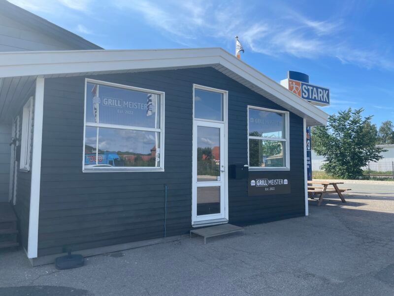 Stark grill bar og restaurant i Sønderborg, med moderne glasdør og fire vinduer samt et flag og parkeringsplads