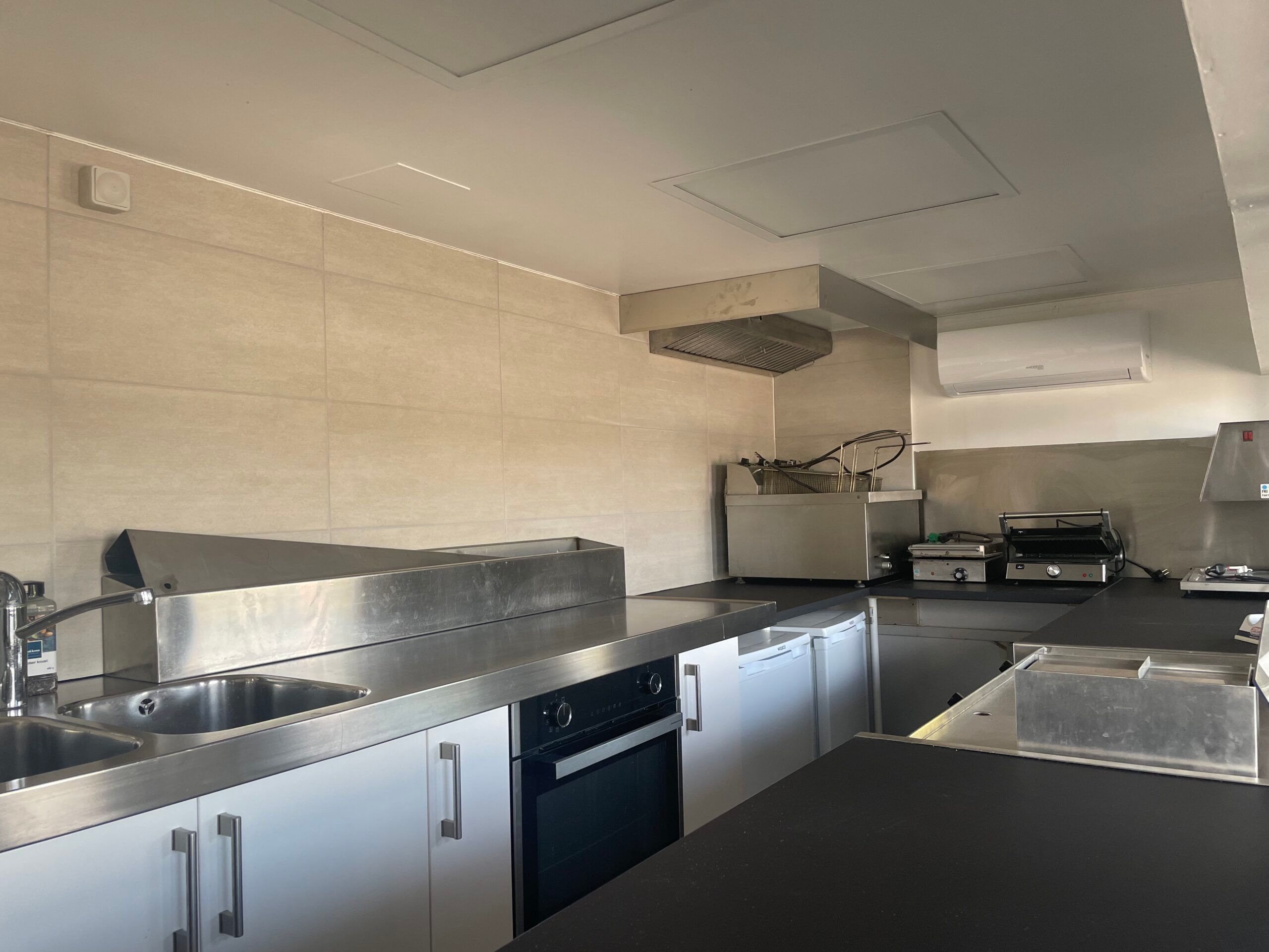 Nyrenoveret køkken med moderne apparater, højkvalitetsmaterialer og lyse vægge, der giver en funktionel og ren stil