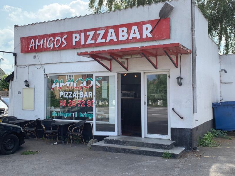 Amigos Pizzabar på Stevnsvej 90 i Strøby Egede med åbent glasdør og udendørs spisesteder. Sort og hvidt indretning og røde