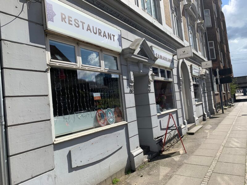 Restaurant “Samarkand” i Århus med vinduerne udsmykket med lysegardiner og refleksioner af byens bygninger