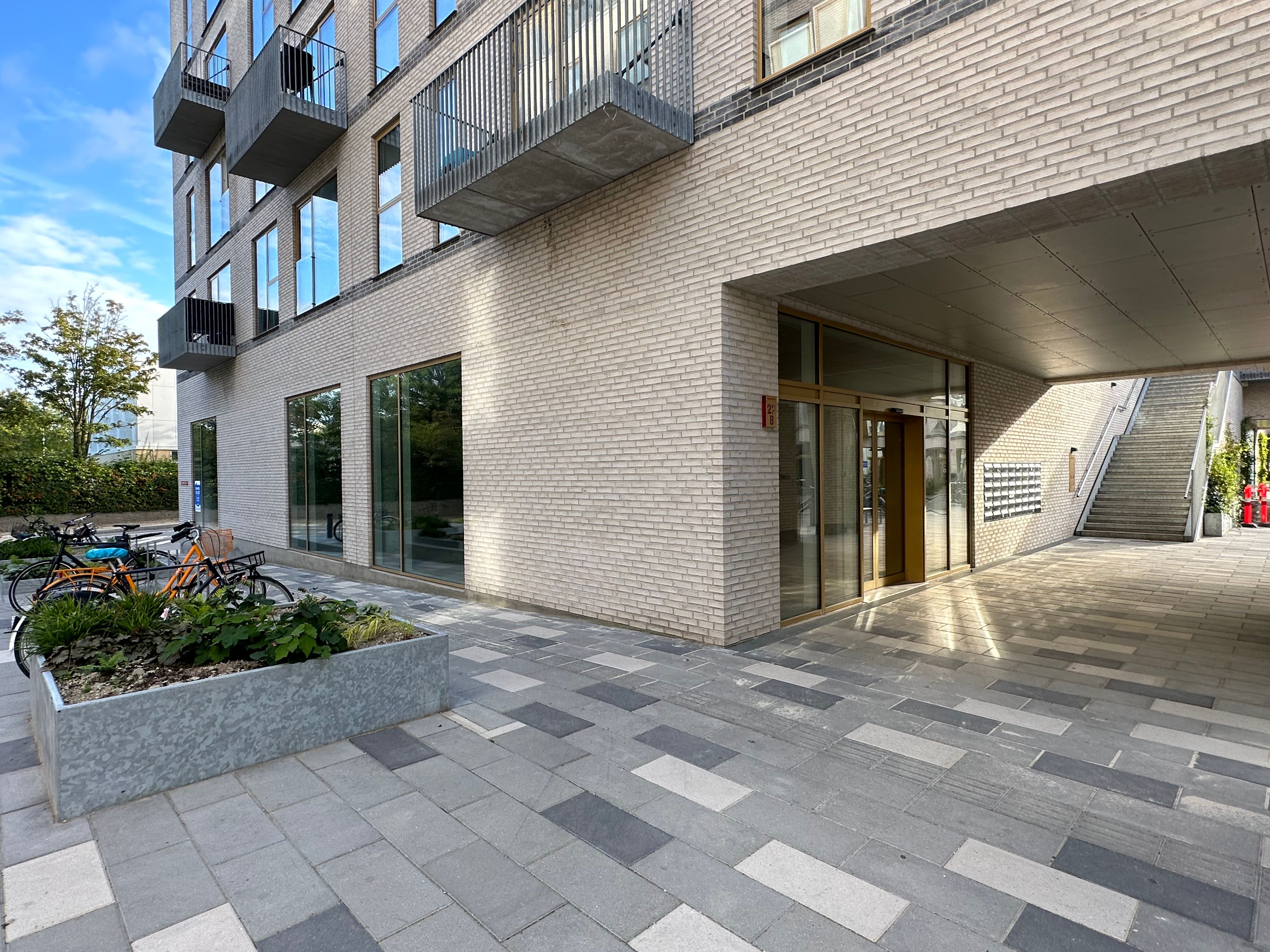Modernt bygning med terrasser og glasvinduer med udgang til forgård og stige til næste etage