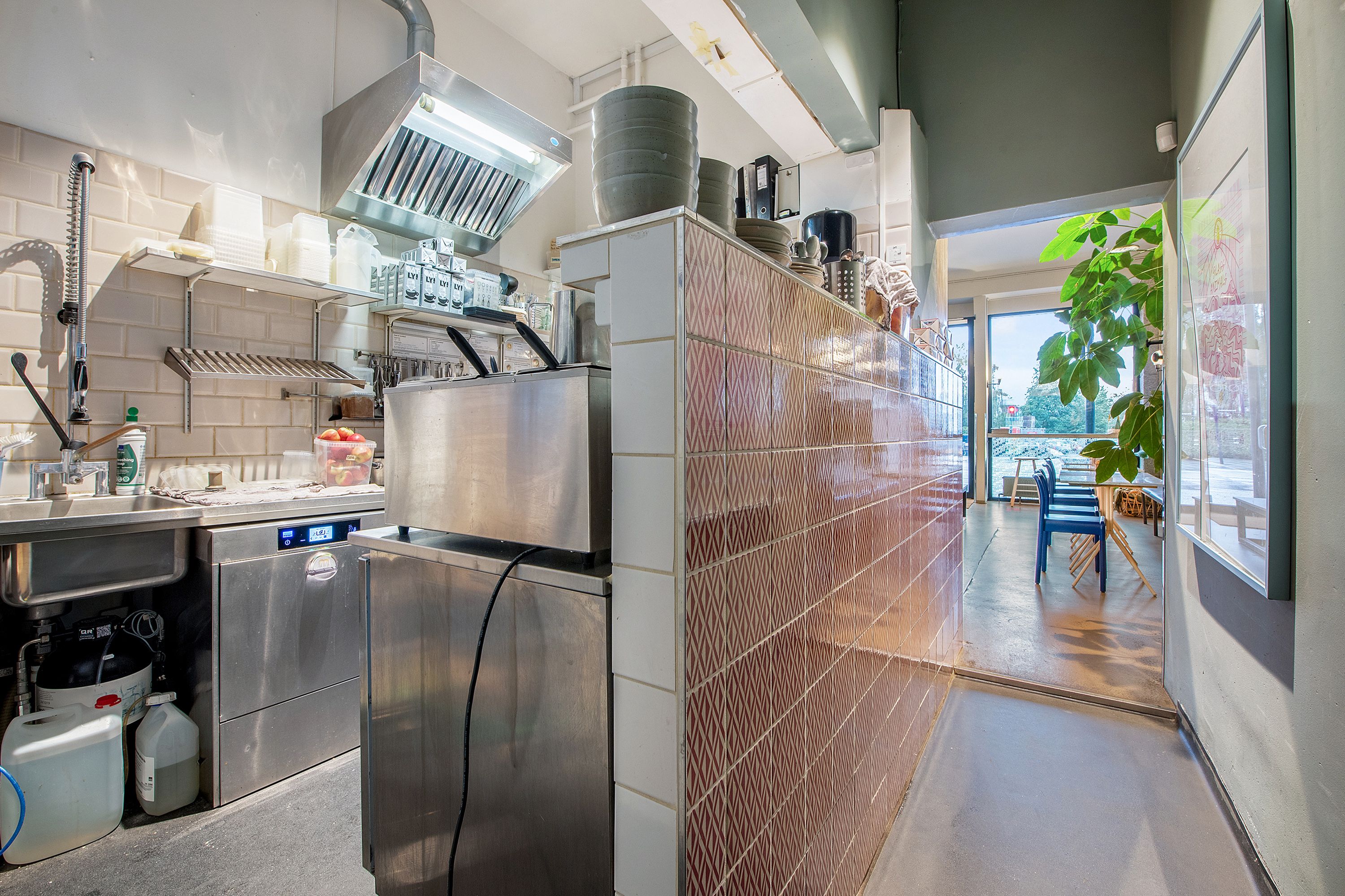 Et moderne køkken med flere apparater og en stor køkkenvæg med en lyserødt og hvidt mønster