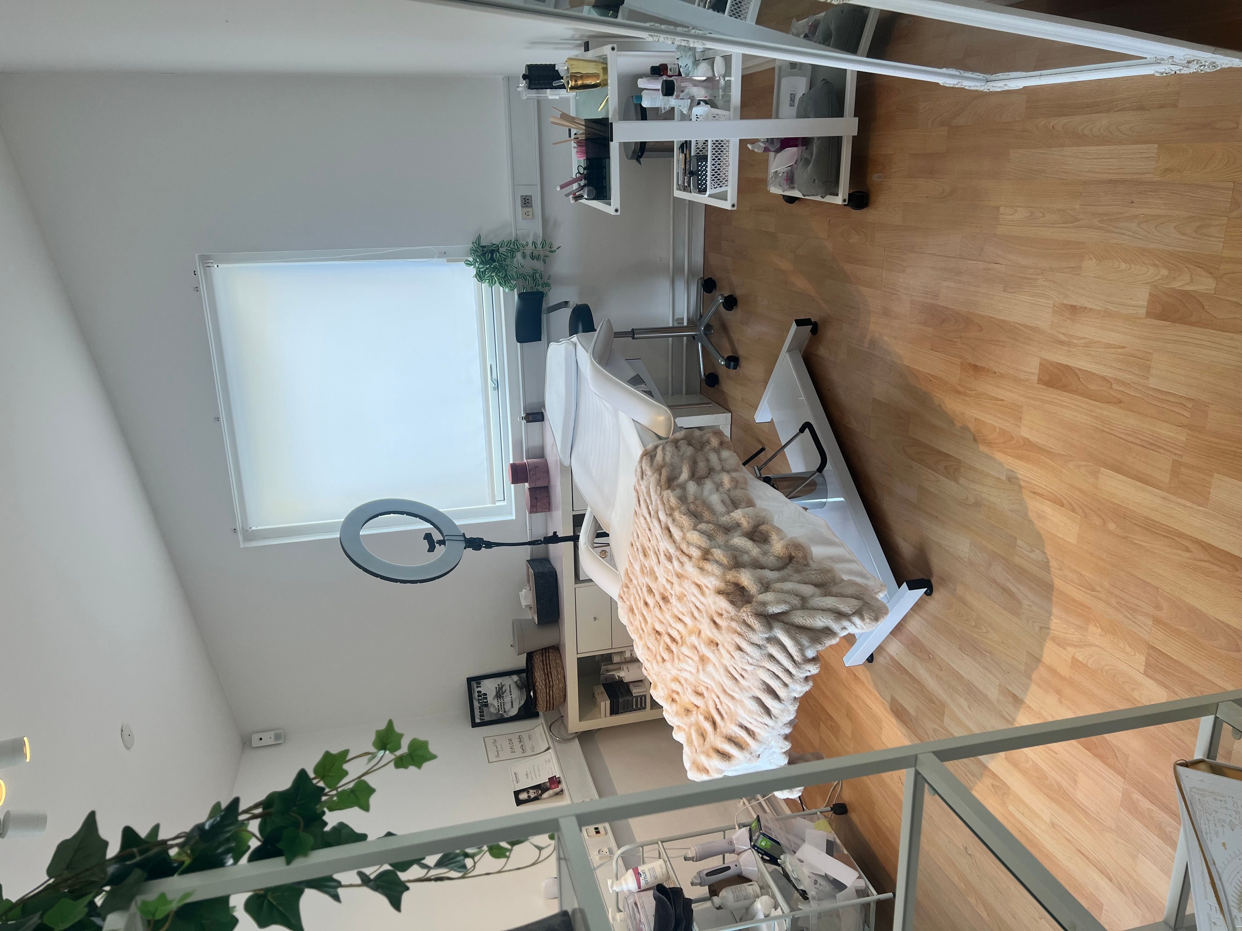 Indvendigt i en luksuriøs klinik med moderne møbler og et luksuriøst hvidt sengehoved med pels.