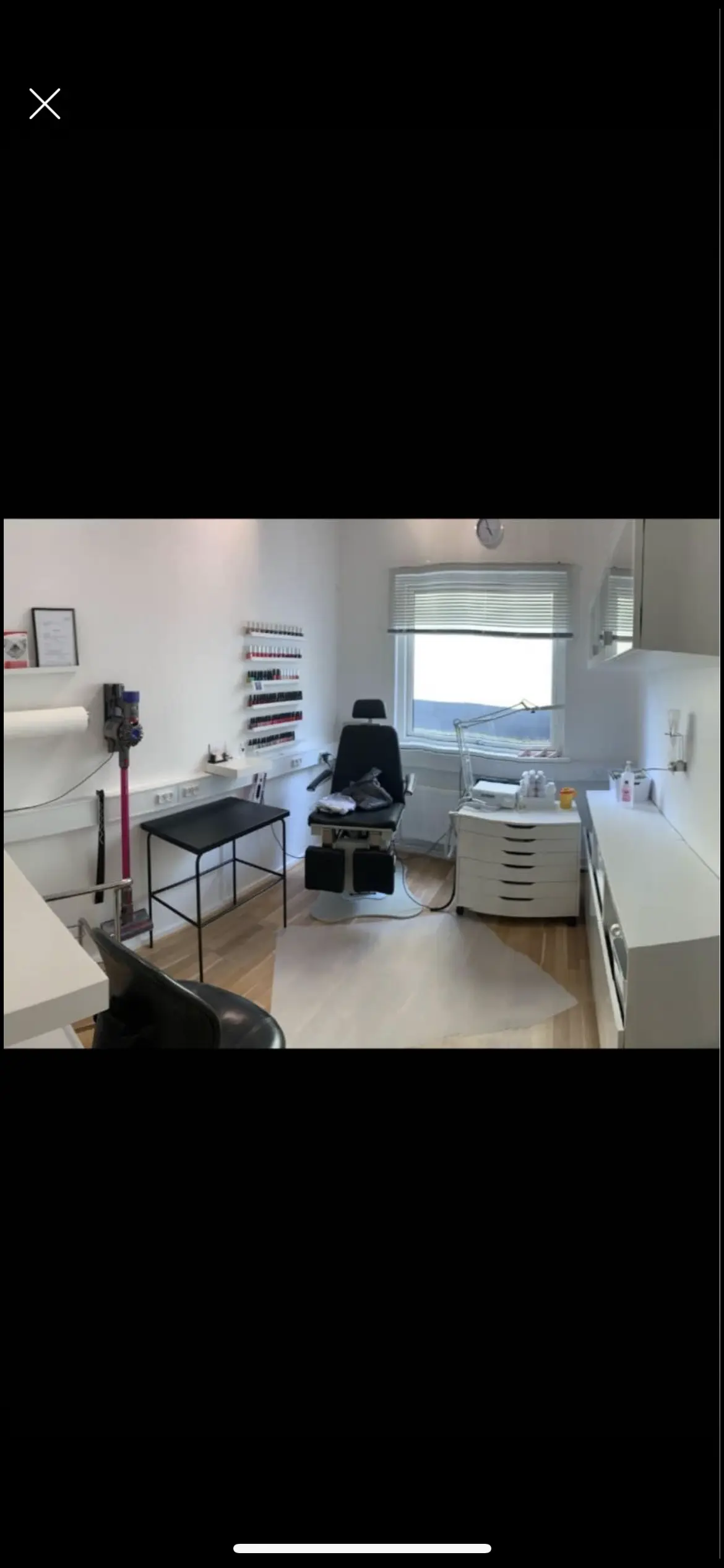 Lokale med tæppe og stol til massage i et værelse med en stol, bord og et vindue med solskin