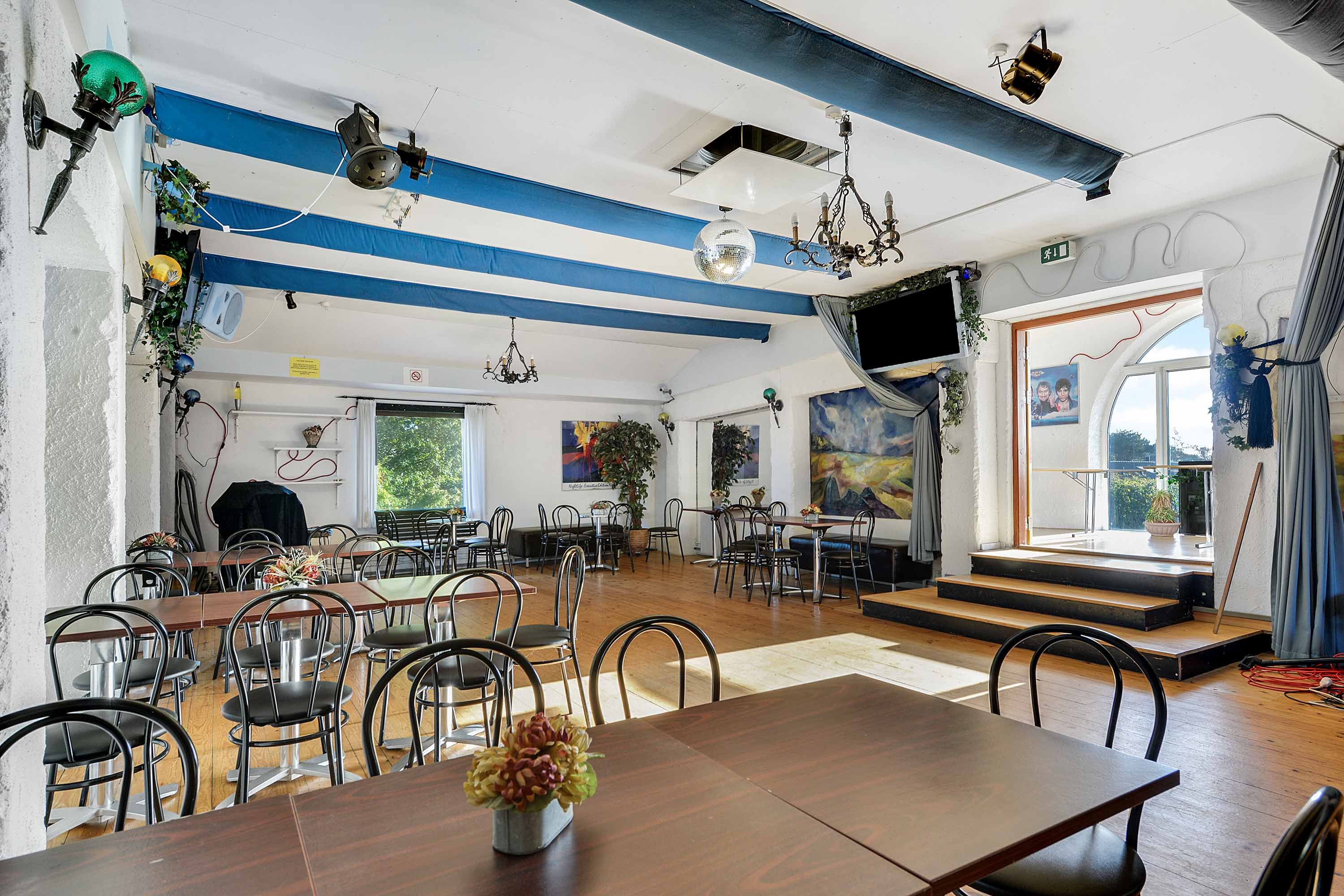 Færdigt køkken med lyse lofter og moderne møbler, lyse gulve og møbler med blomster i lyse farver og diskotekugle i loftet