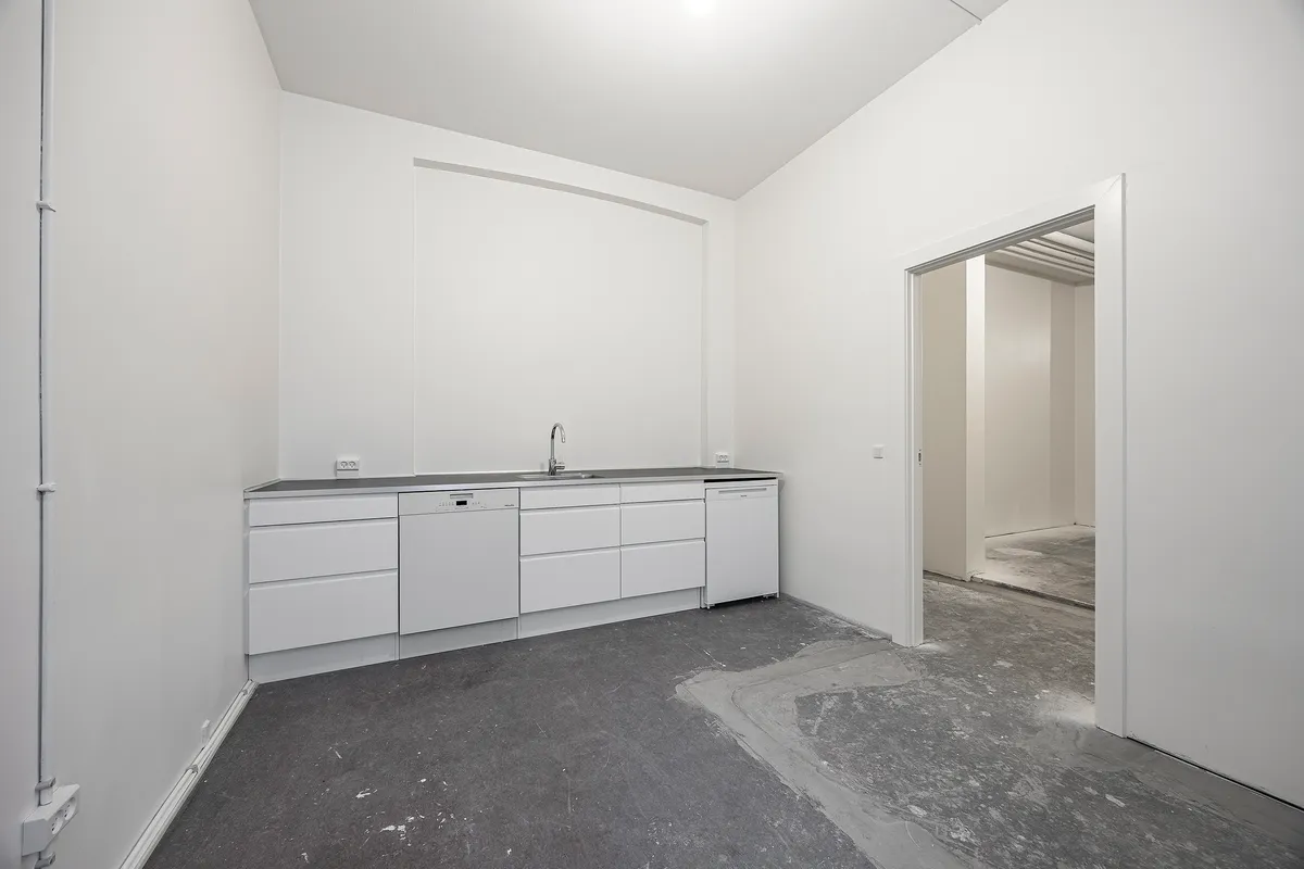 Moderne hvidt køkken med lyse gulv og vægge, skarpe linjer og moderne design, lyse og rummelige rum med lysegulv og vægge