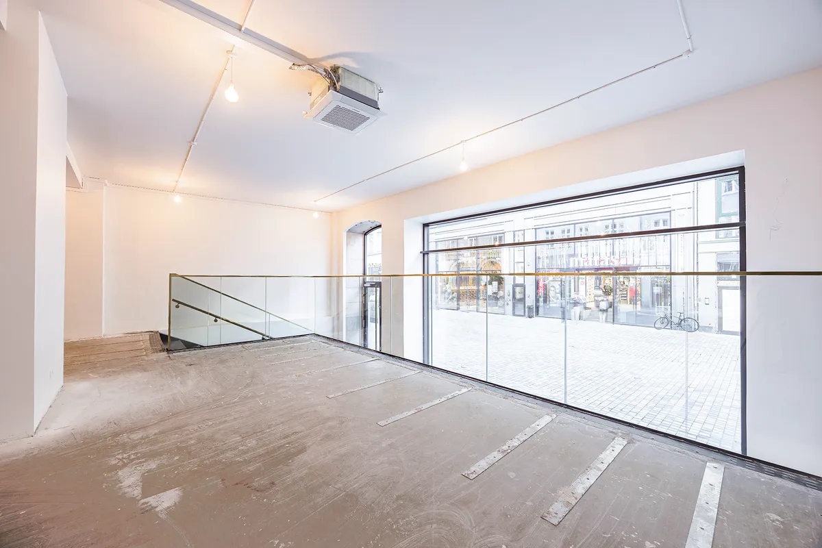 Moderne butik med gulv til loft vinduer og udsigt til Købmagergade, samt åben balkon og hængende lysekroner