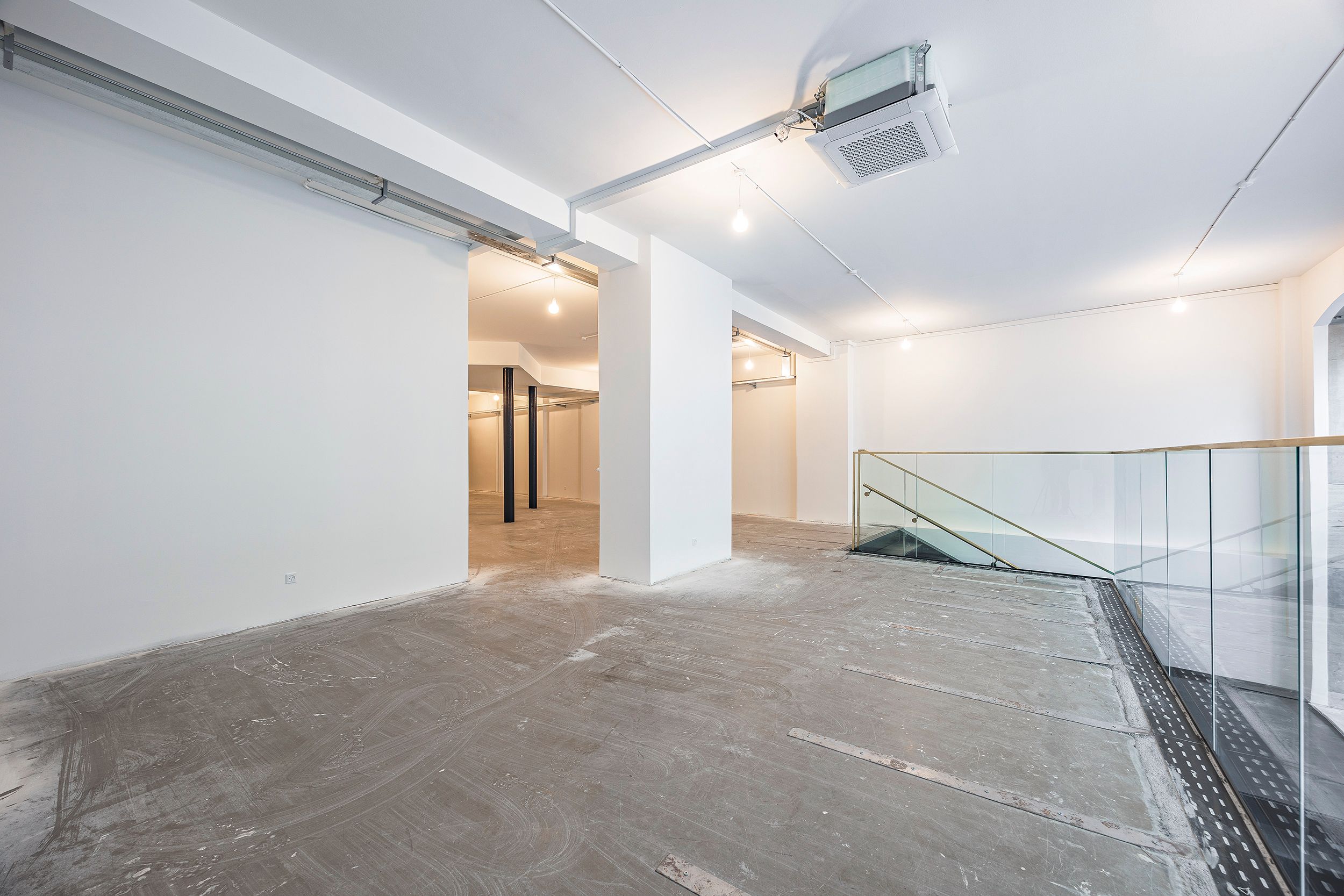 Ledig og velbeliggende butikslejemål med glasgulv og stående glasvægge, samt store, lyse og åbne områder