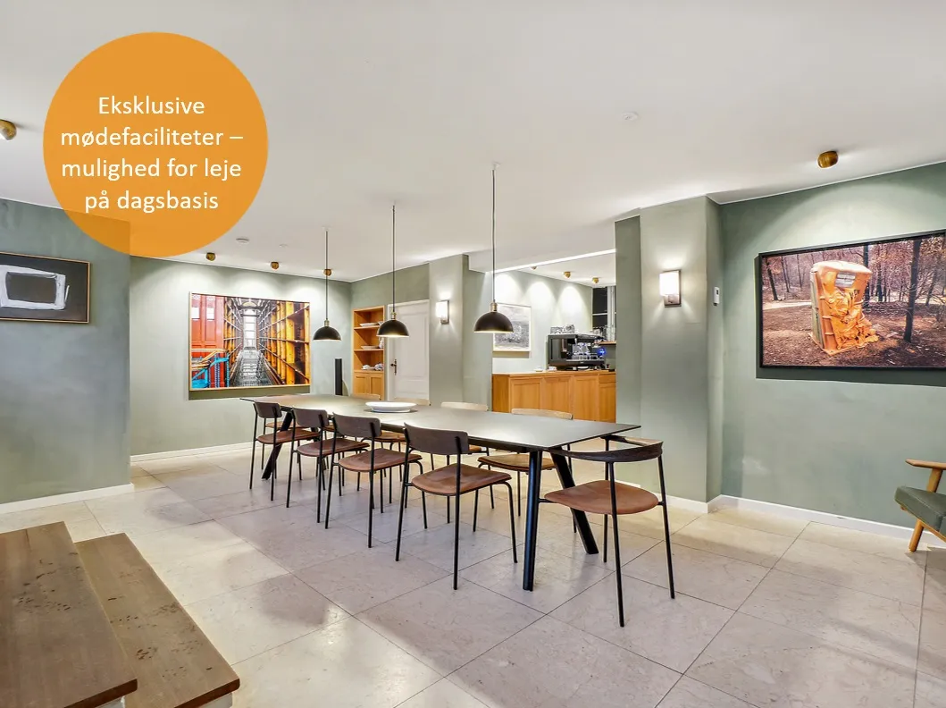 Elegant stue med bord og stole, tv og kunstværker på væggen og smukke møbler og lys.