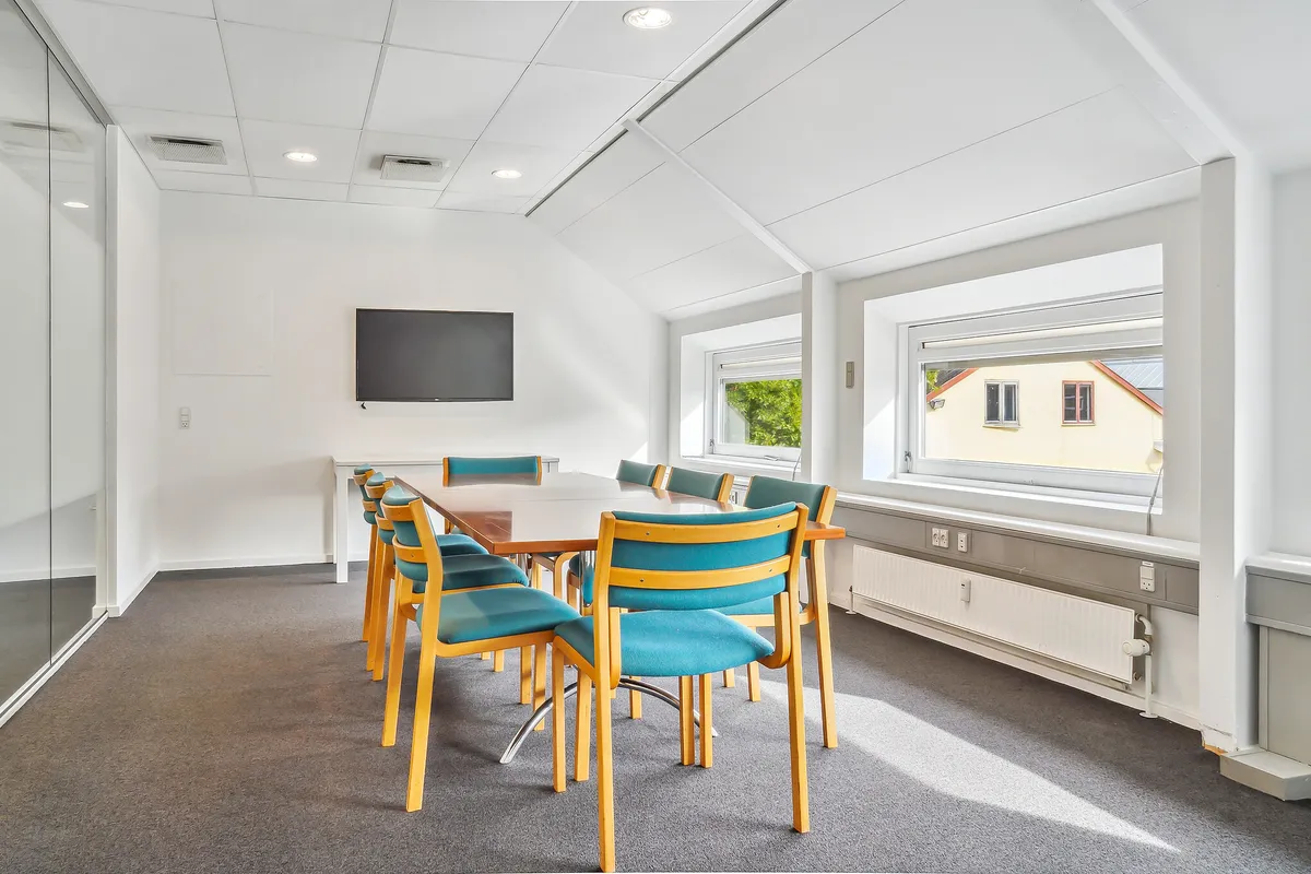 Mødelokaler med lysegul gulvbelægning og lysegrå vægge. Gulvet er lysegråt og gulvet er lysegråt. Lokalet er udstyret med