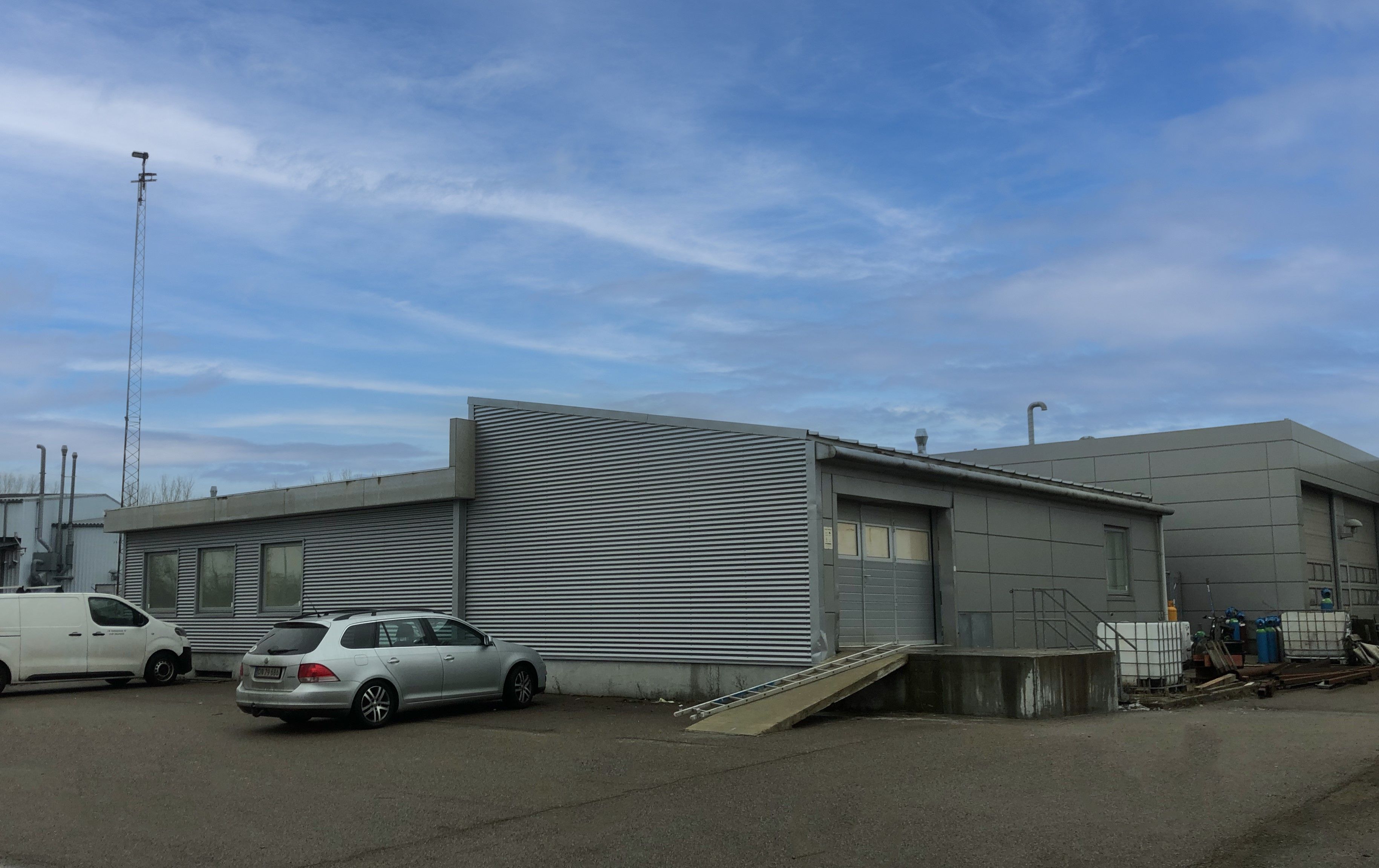 Lejlighed til overtagelse med 337 m² og to parkerede biler på forsiden af bygningen.