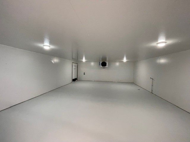 Et stort, renskurert og hvidt lager med åben dør og ventiler i loftet