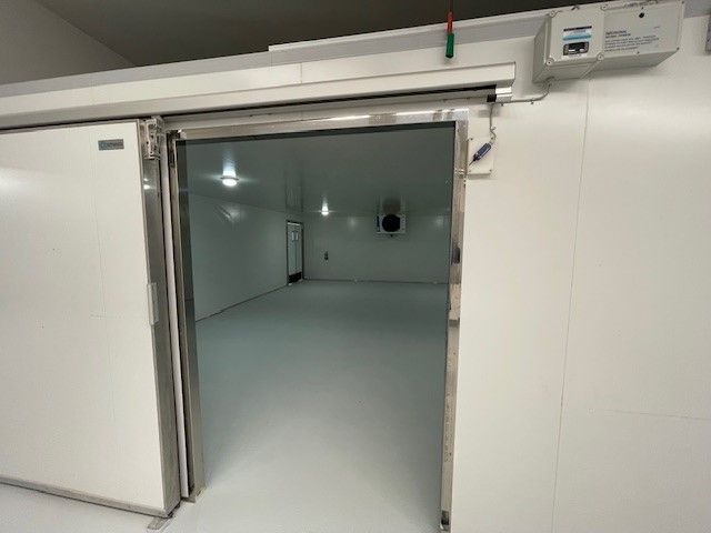 Lejet er et lager med dobbeltdør, der er 70 m² stort, og der er en AC-enhed monteret på væggen