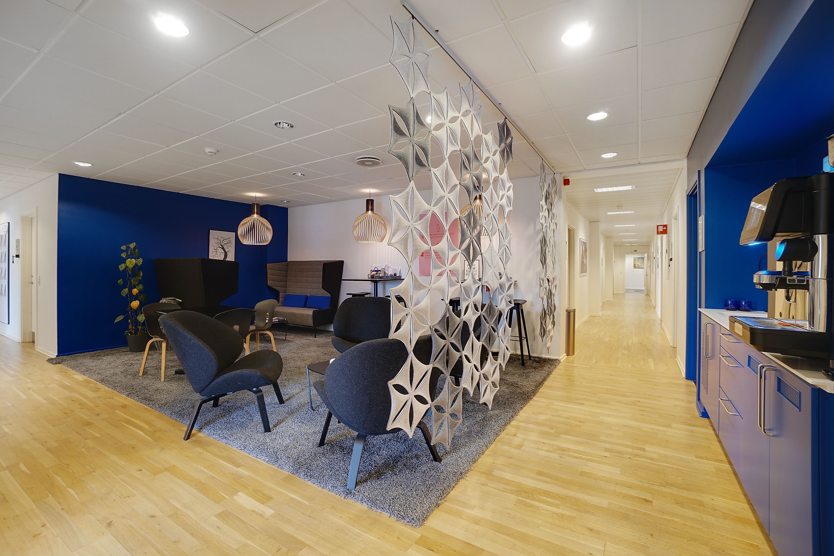 Moderne kontor med lysegul gulv, højt loft, lysepunkter, møbler og søjler med mønstre