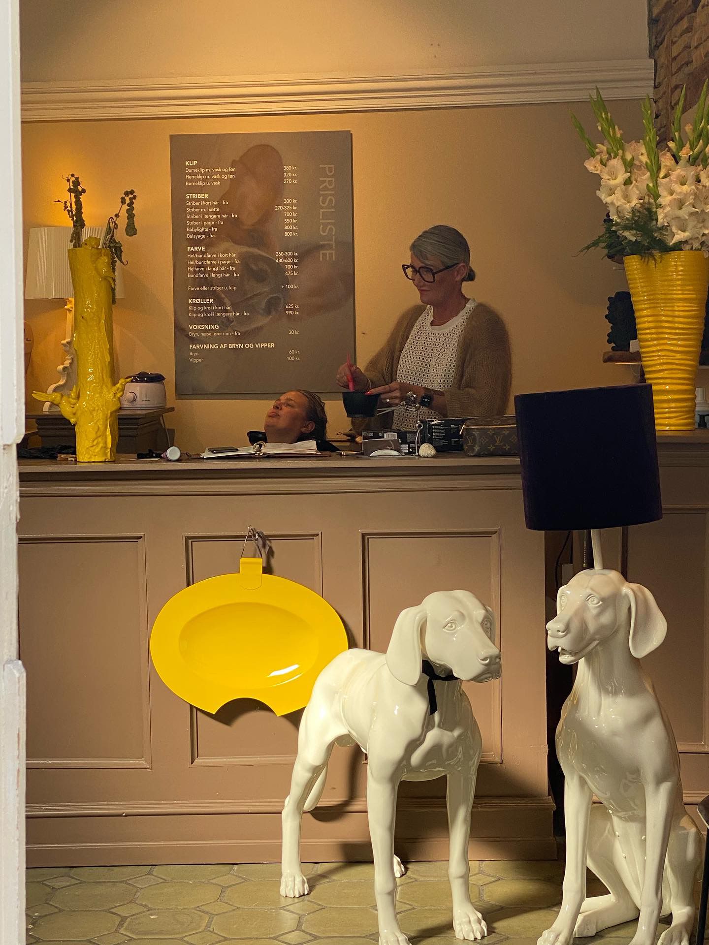 I receptionen er der en kvinde og en hund samt to store hundestatuer og en kæmpe gul plade