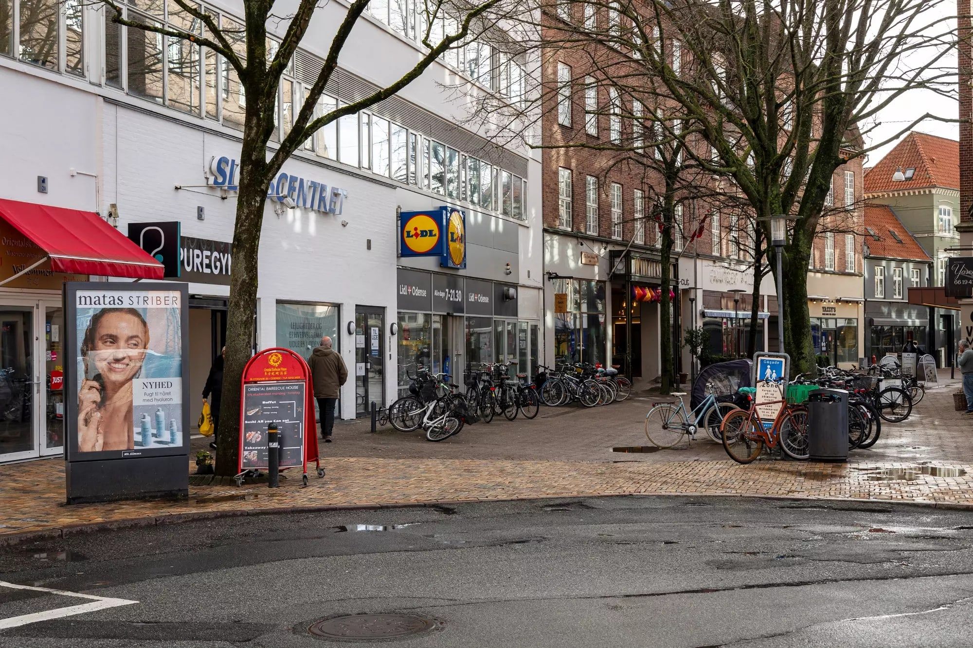 Butiksgade med Lidl og Matas Striber i Odense City med cykler og gående mennesker