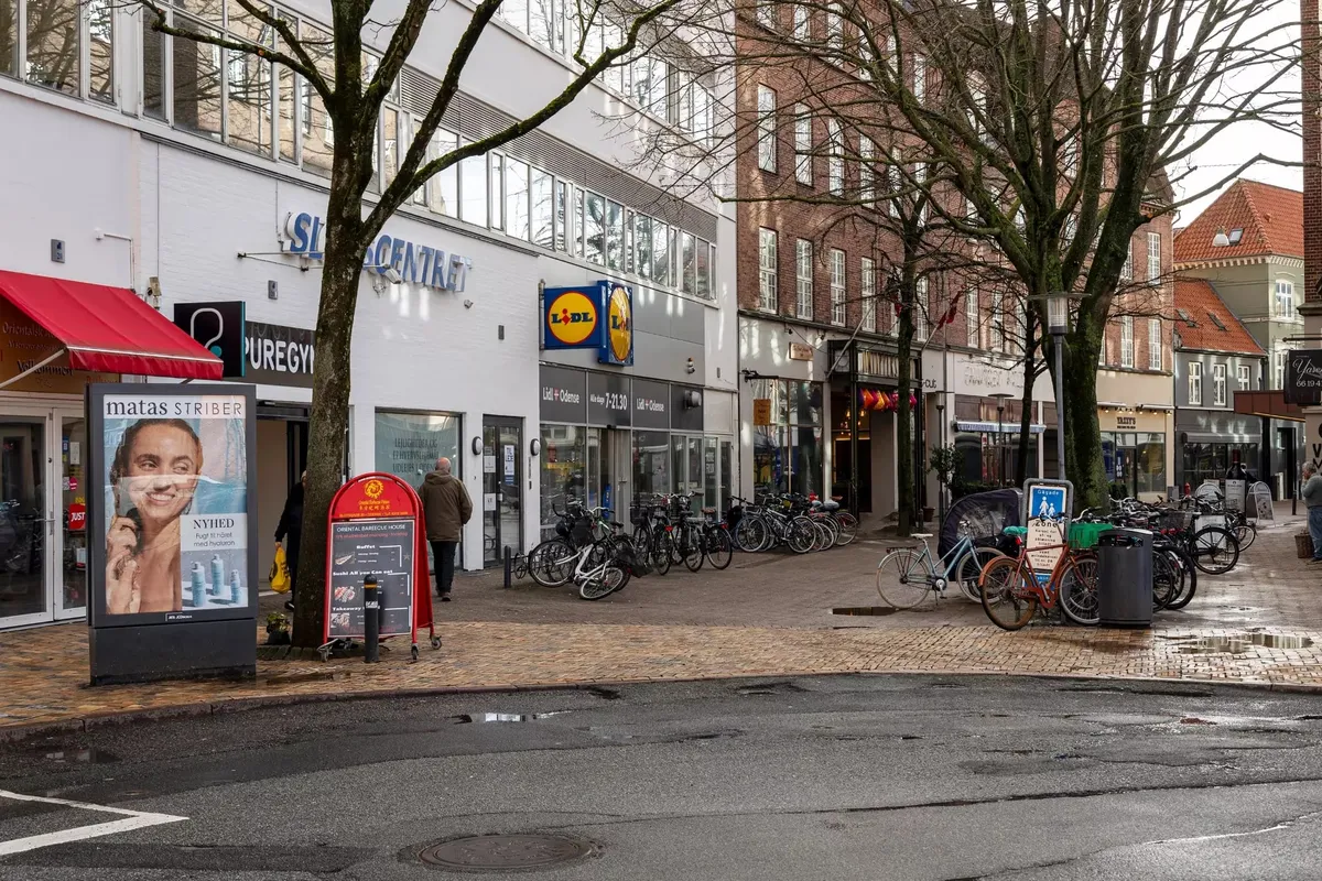 Butiksgade med Lidl og Matas Striber i Odense City med cykler og gående mennesker
