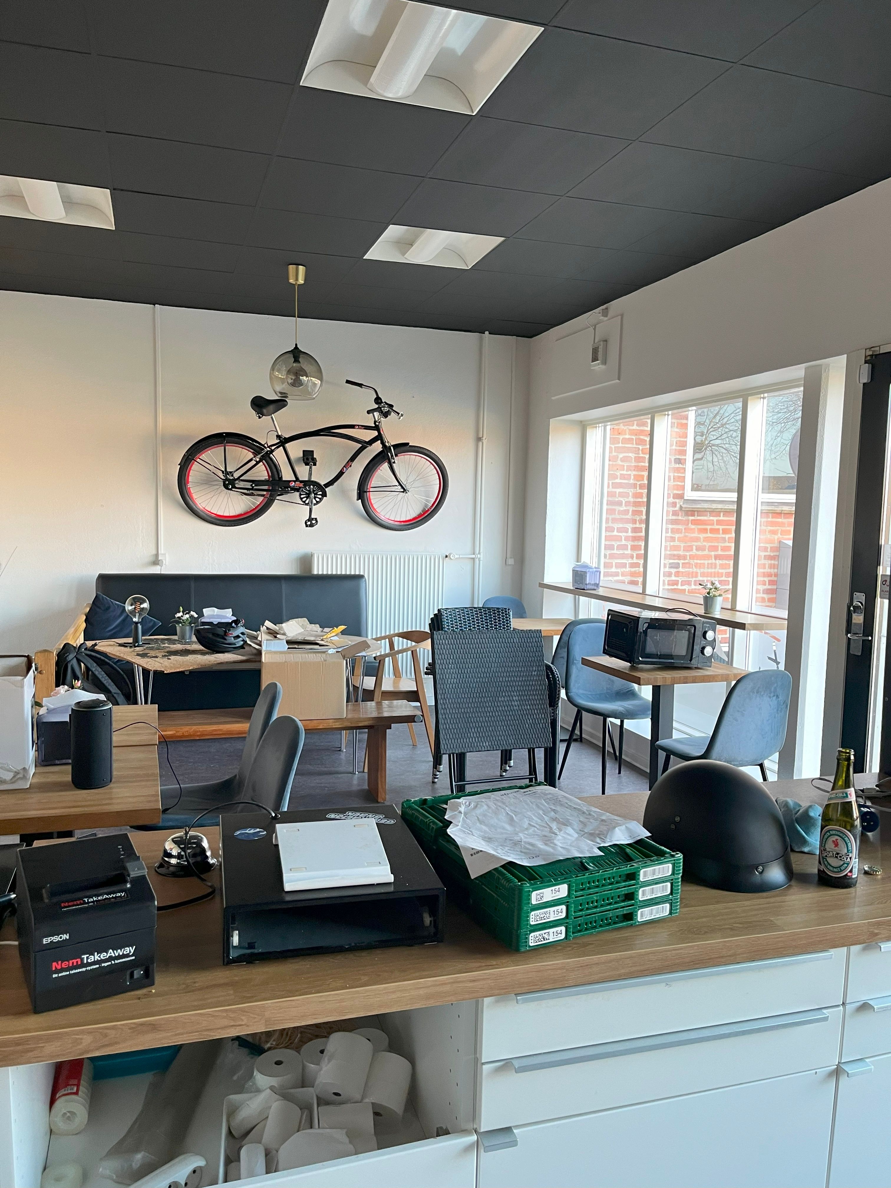 Dansk burgerbar i Viby J, Aarhus med udsigt til gaden, udstyret med borde og stole samt et sælgersystem og et lager med