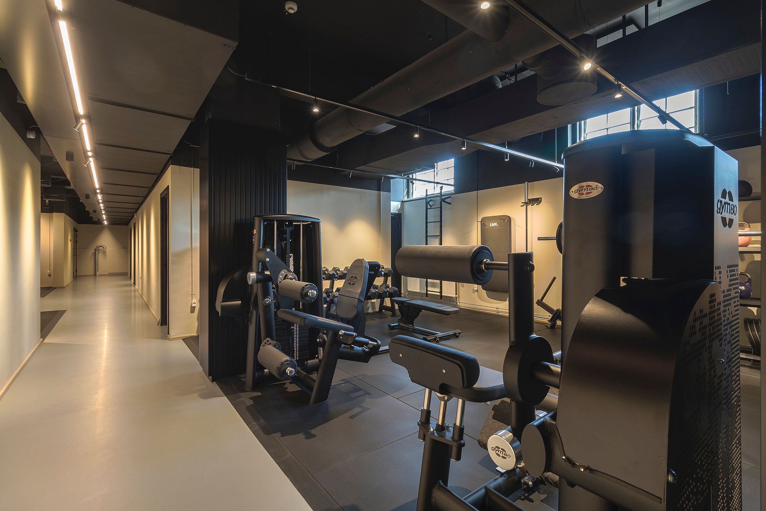 Fitnesscenter med moderne og funktionelle fitnessapparater, højt til loftet, lyse og rene omgivelser