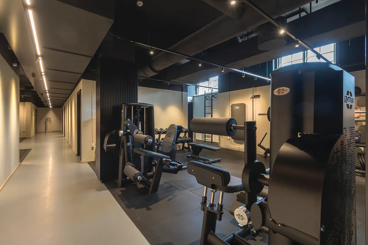 Fitnesscenter med moderne og funktionelle fitnessapparater, højt til loftet, lyse og rene omgivelser