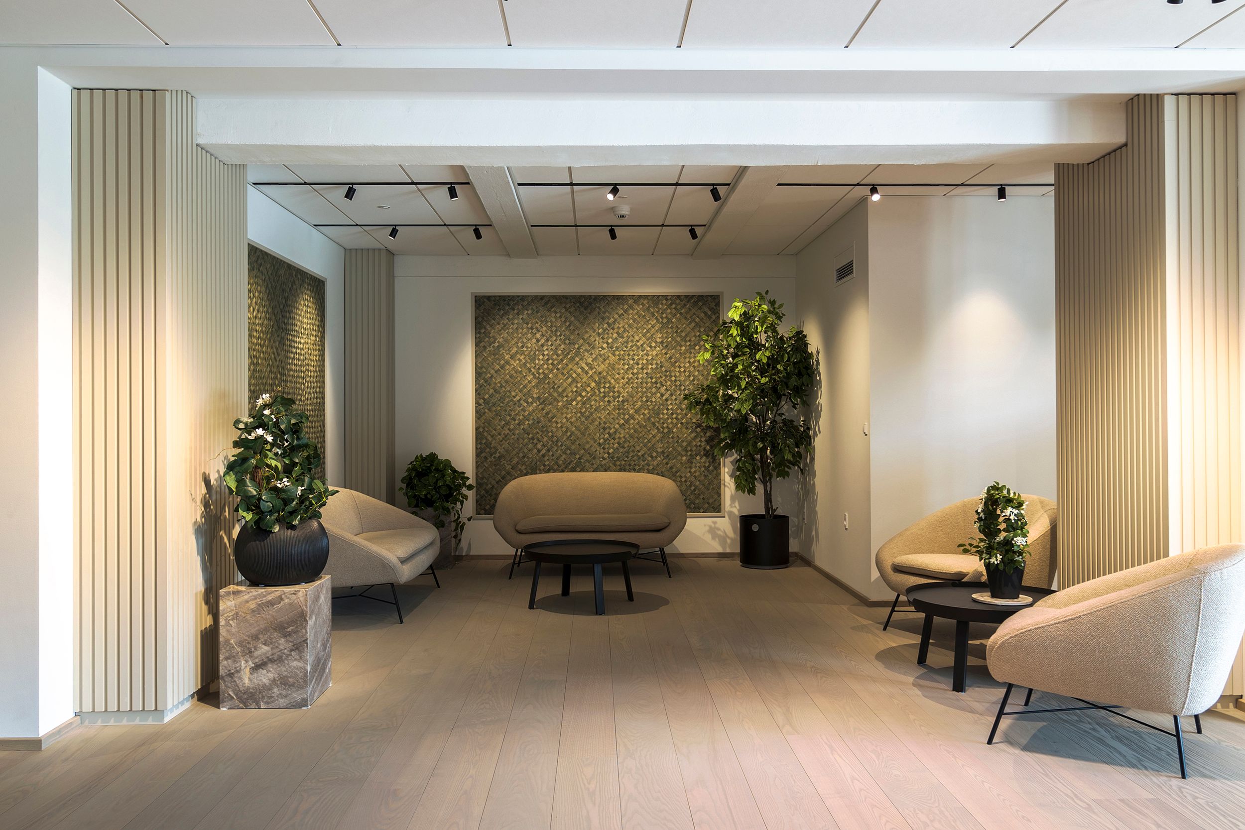 En luksuriøs lobby med lyse og moderne møbler, en massiv trægulv og store plantager for at give et varmt og velkommet