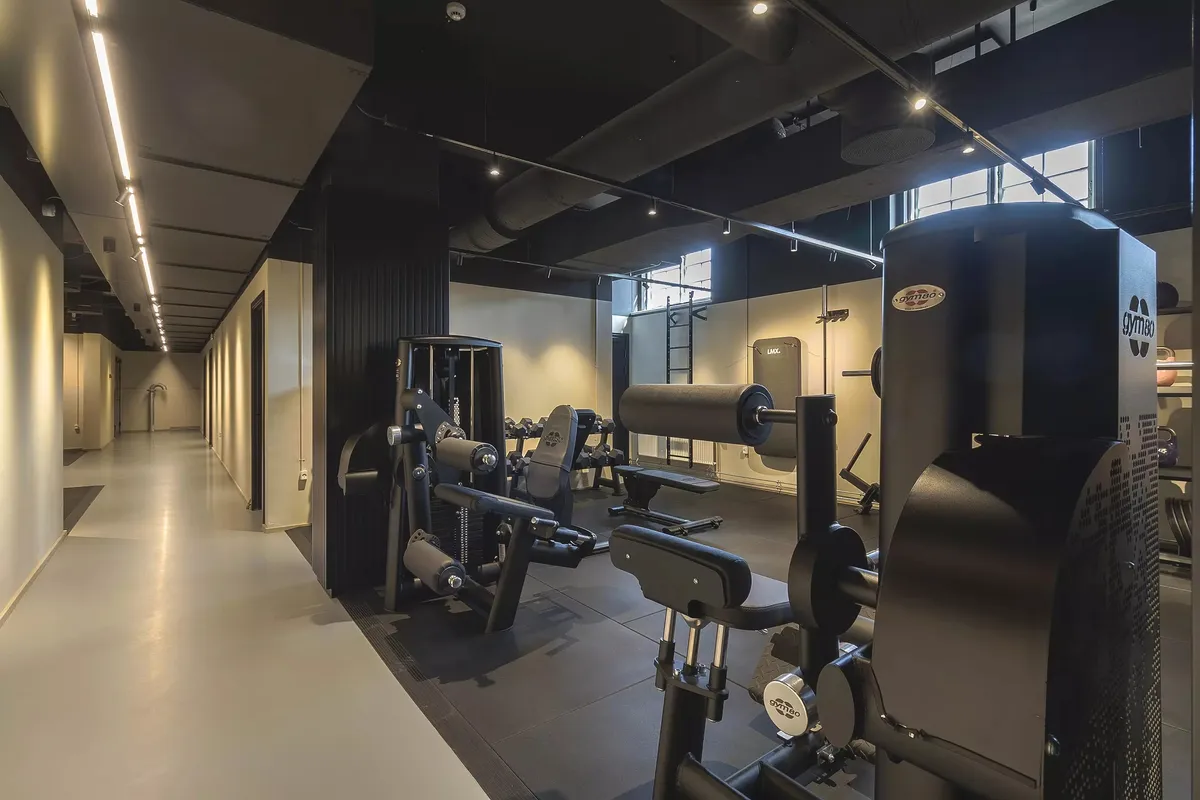 En slank, mørk farvet træningssal med moderne træningsapparater og en åben vinduesparti