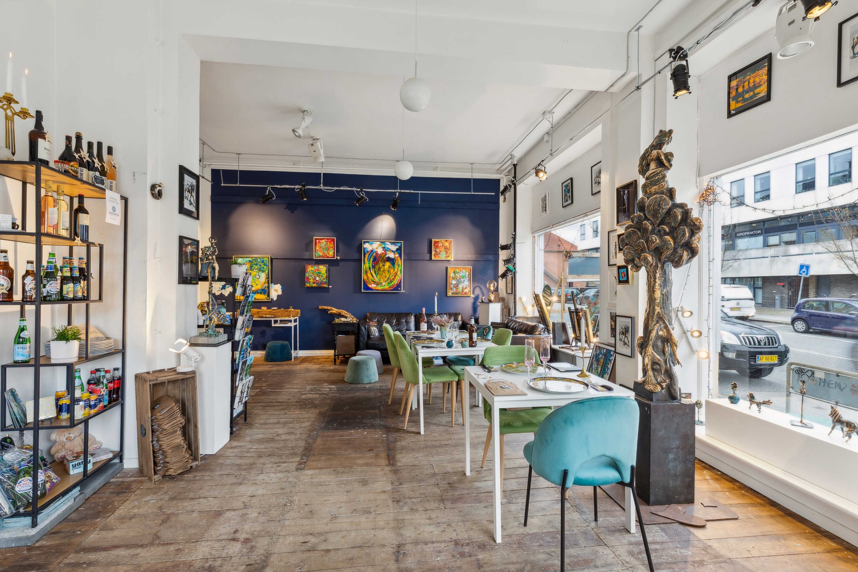 Indenfor dette hyggeligt indrettede lokale, er der et borde og stole samt kunstværker og skulpturer på væggen. Gulvet er