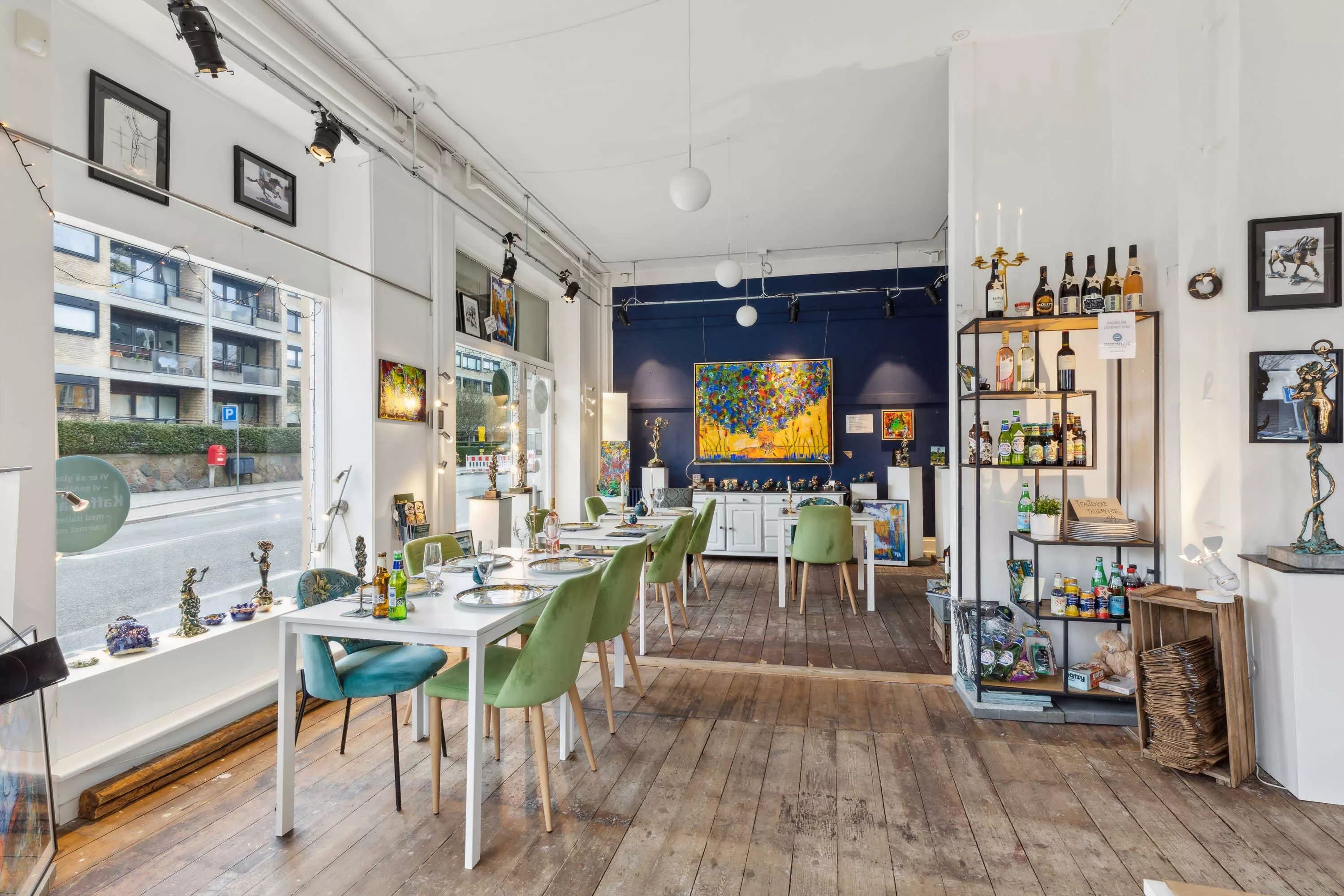 En stue med en lang spisebord og stole samt et hylde med flere vinflasker og andre drikkevarer.