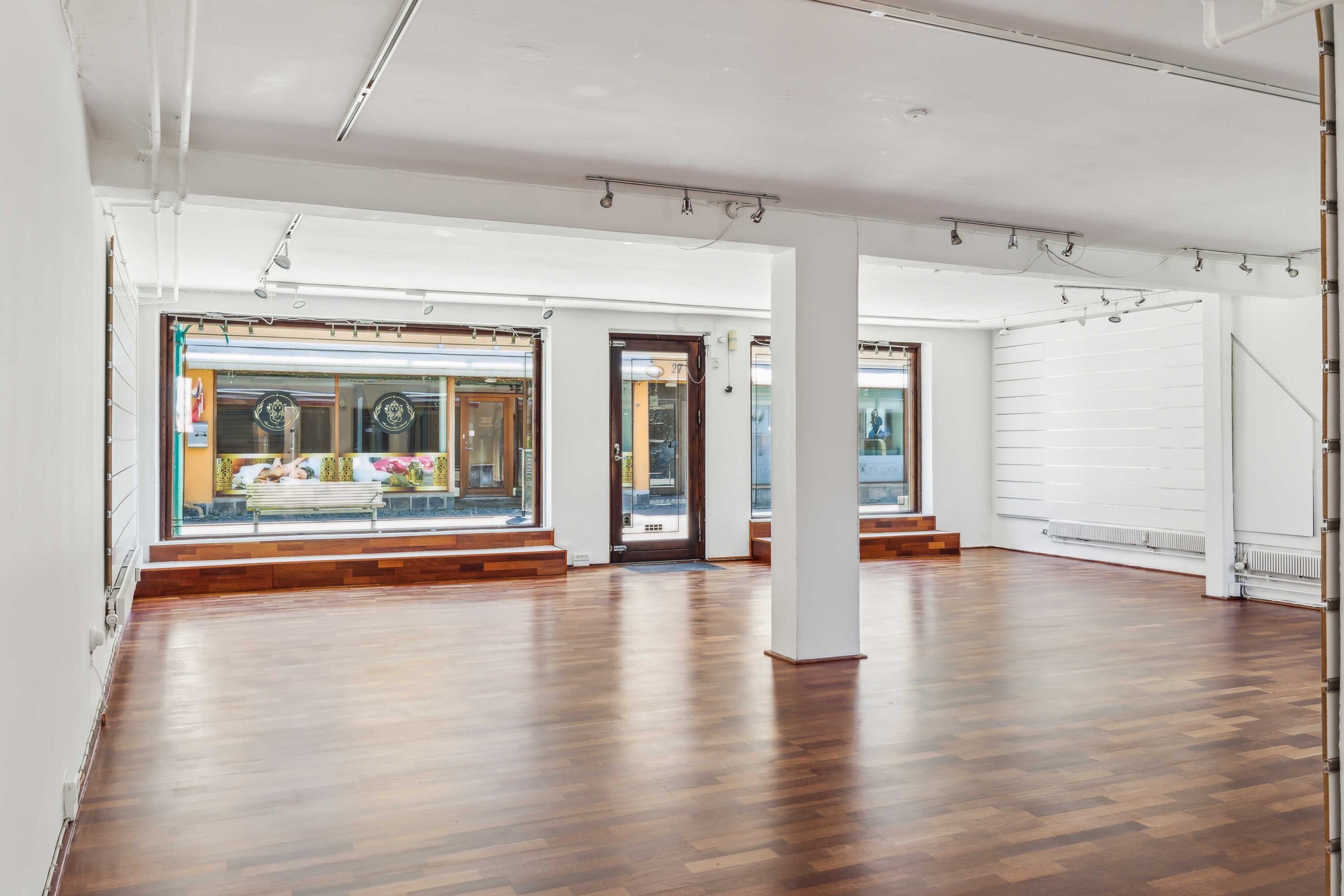 Lejlighed med gulvbelægning og store vinduer. Moderne og lysfyldt interiør med trægulve og hvide vægge. Minimalistisk design